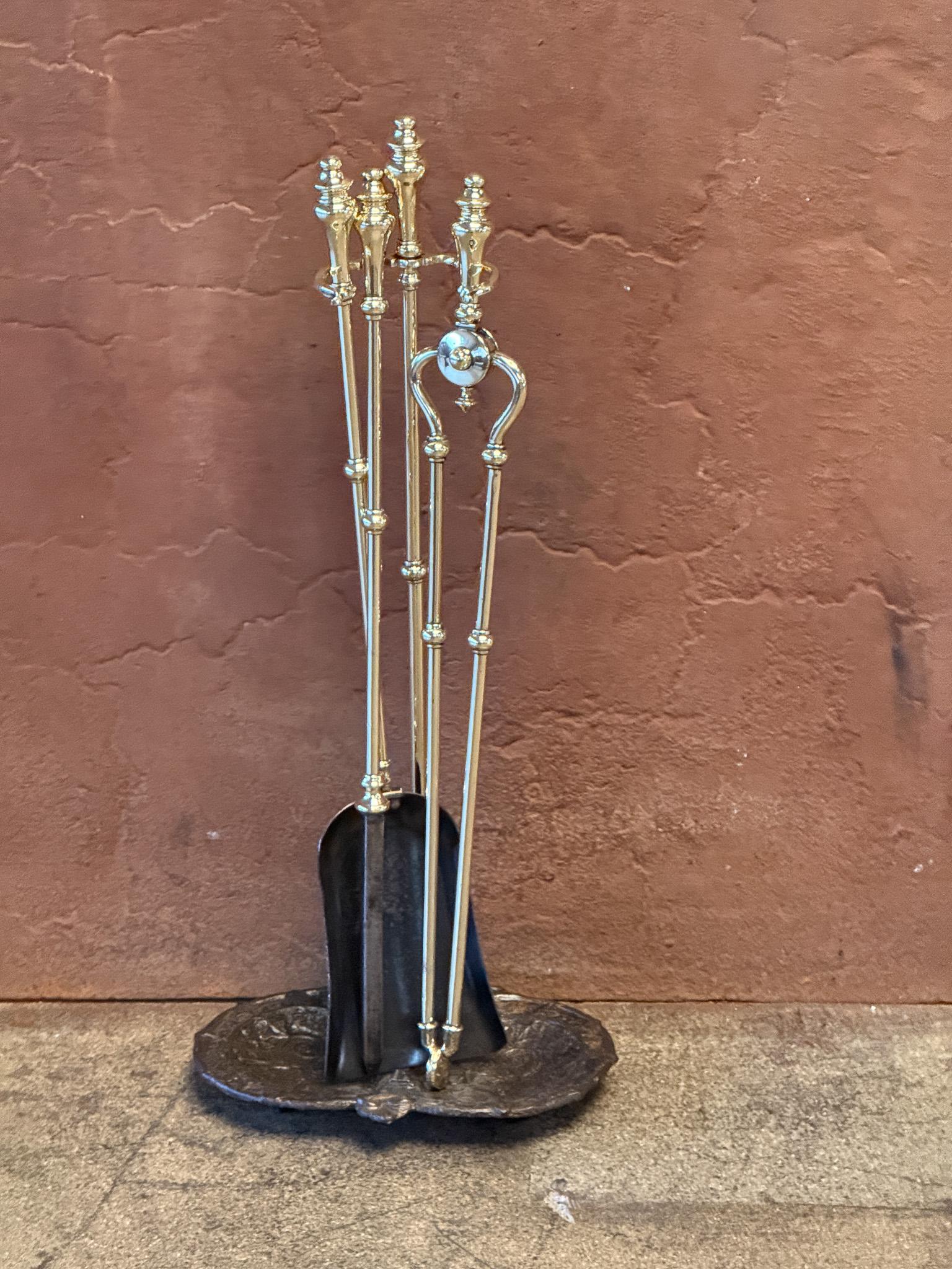 Set di attrezzi per caminetto del XIX secolo in stile vittoriano inglese. Gli strumenti sono realizzati in ottone lucido e ferro battuto, mentre il supporto ha una base in ghisa. Il set di attrezzi è composto da pinze, pala, attizzatoio e supporto.