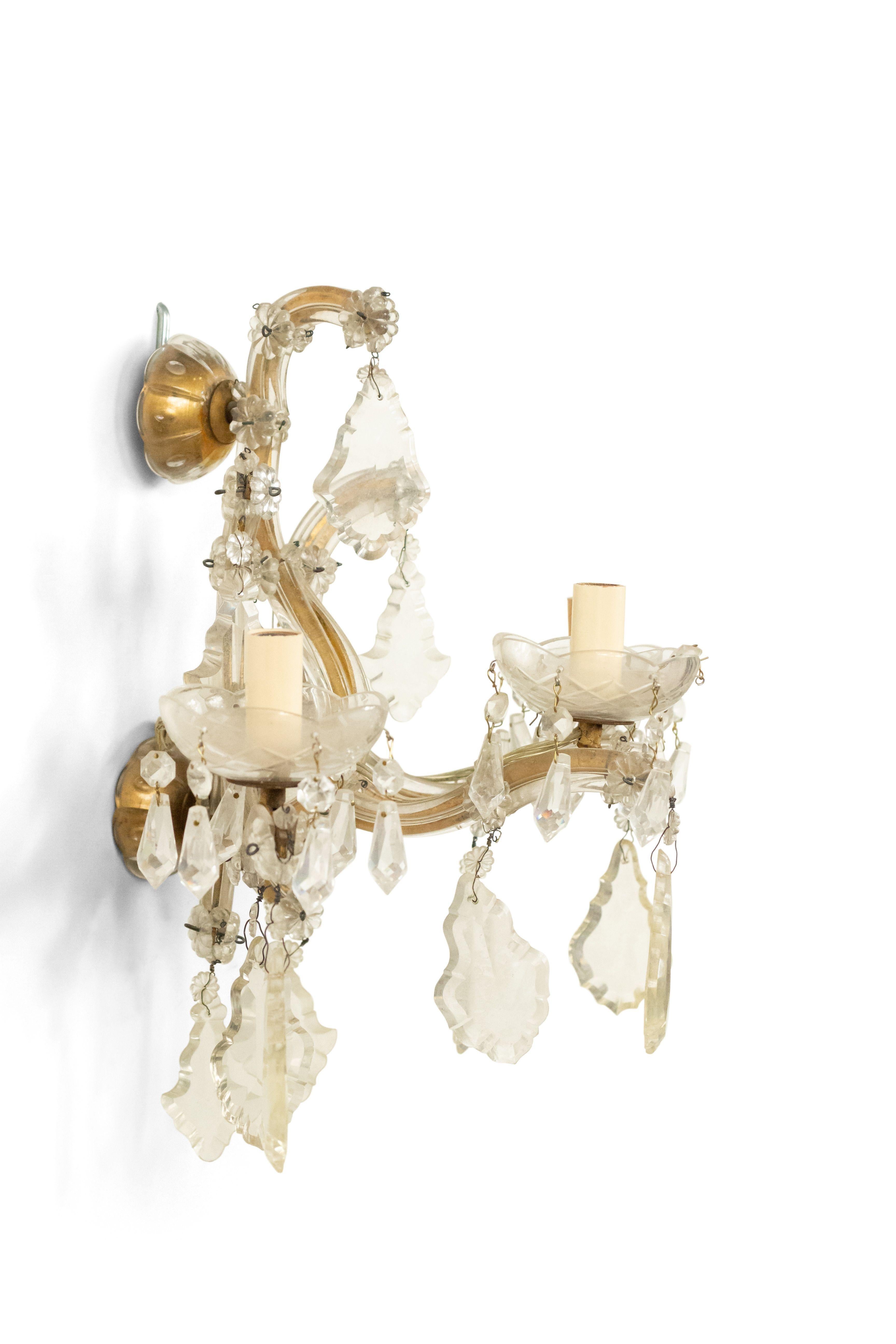 English Victorian style (20th Century) gilt metal and crystal wall sconce with three arms, dangling crystals, and etched bobeches.
 