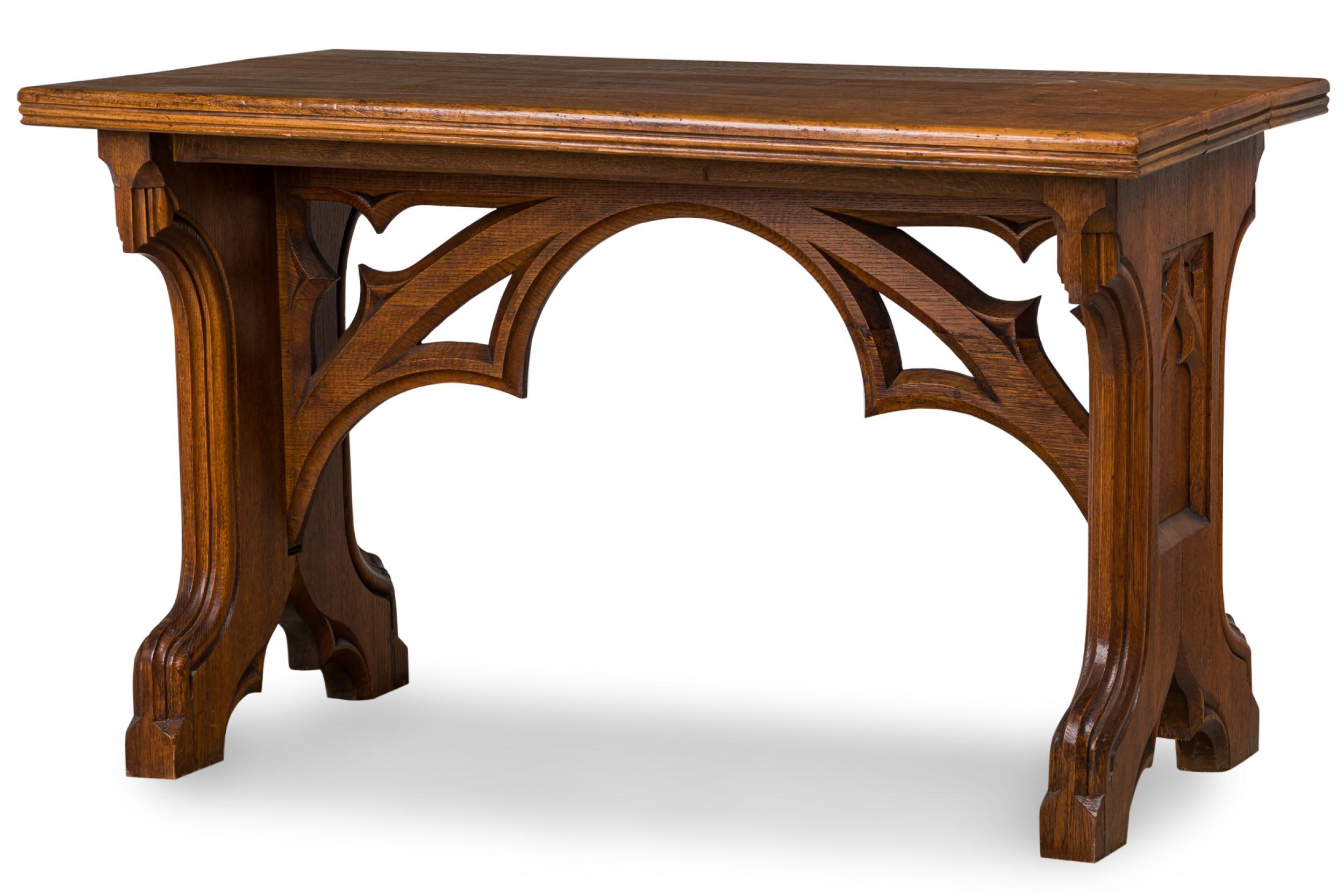 English Victorian Gothic Revival (late 19th Century) carved oak rectangular table resting on two wide carved legs connected at center under the tabletop by two arching carved open supports.