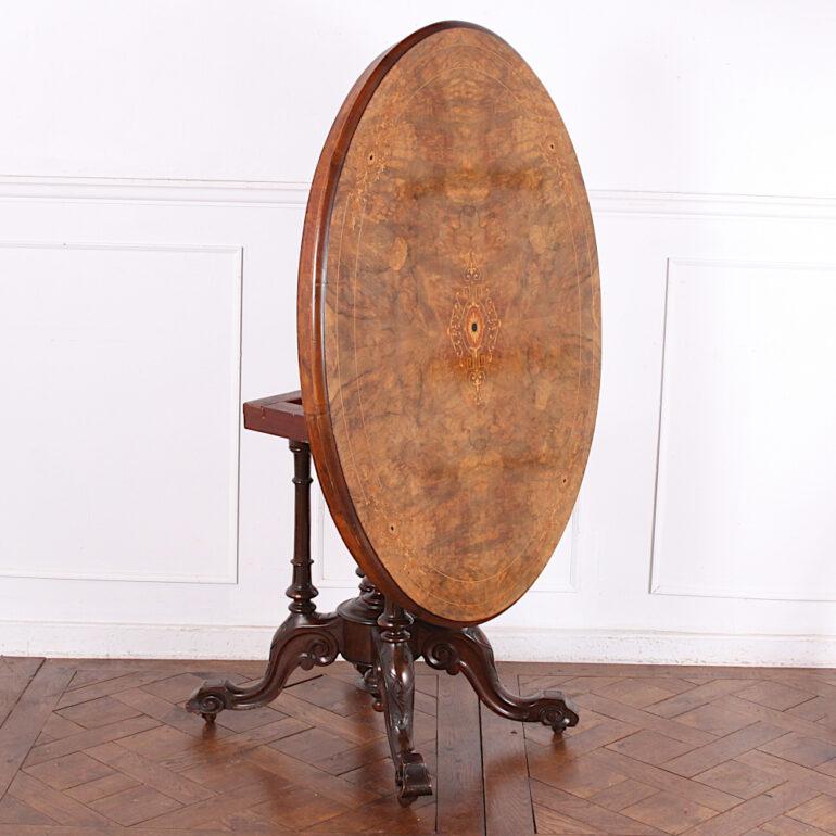 Victorian inlaid figured walnut “loo” table or parlour table, the oval top with book-matched burl walnut and intricate inlay and stringing in amboyna, boxwood ebony etc. The top tilts up on its original brass thumb screws for space saving and to