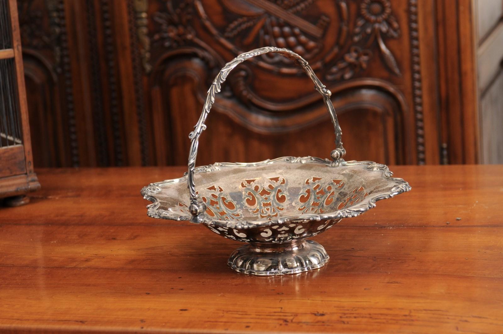 An English Victorian period Melvin Pratt round silver cake basket from the late 19th century, with pierced design and foliage motifs. Created in England by Melvin Pratt during the later years of the Victorian era, this silver piece features a