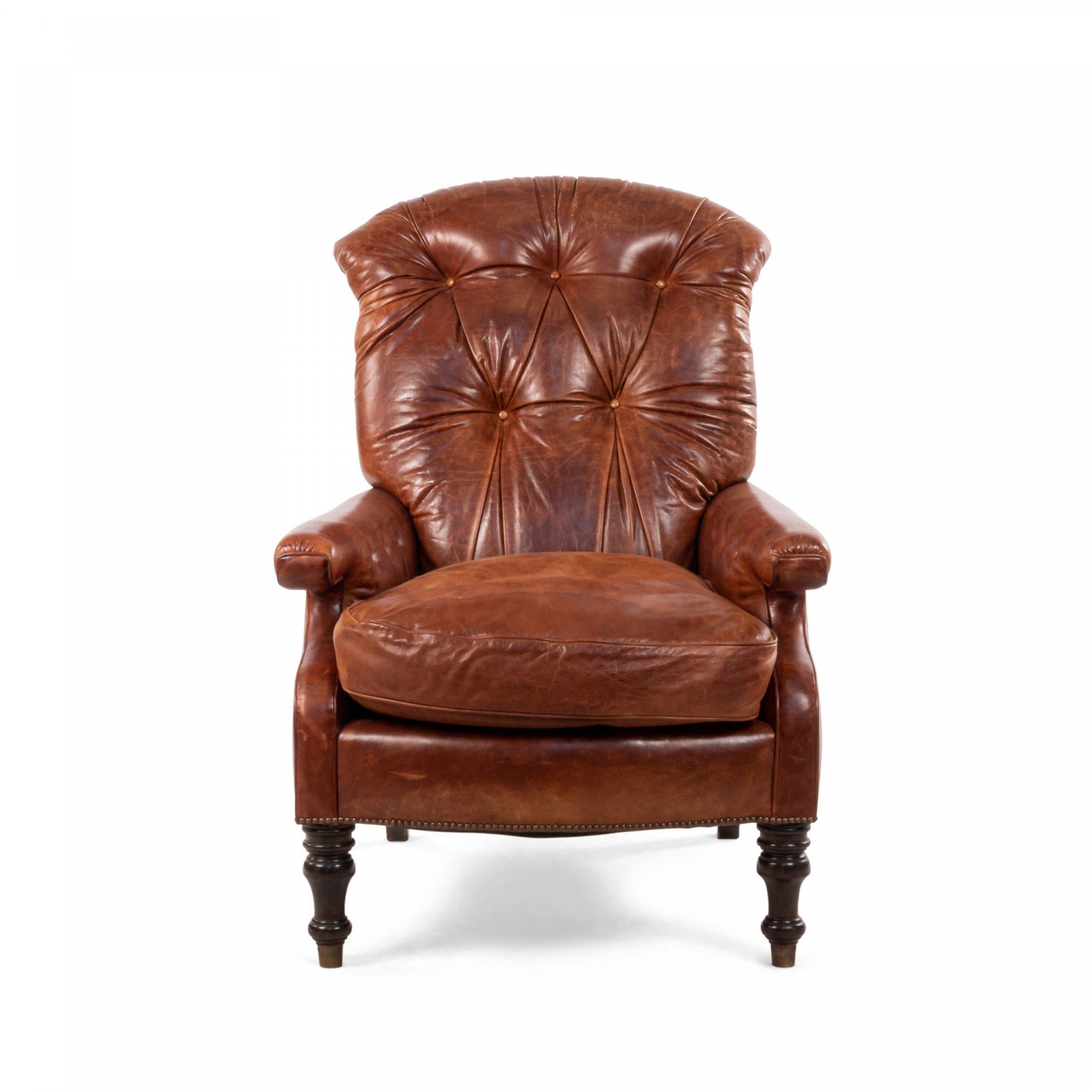 English Victorian Edwardian-style modern chestnut brown leather tufted back easy chair with turned mahogany legs ending in brass caps. 
 