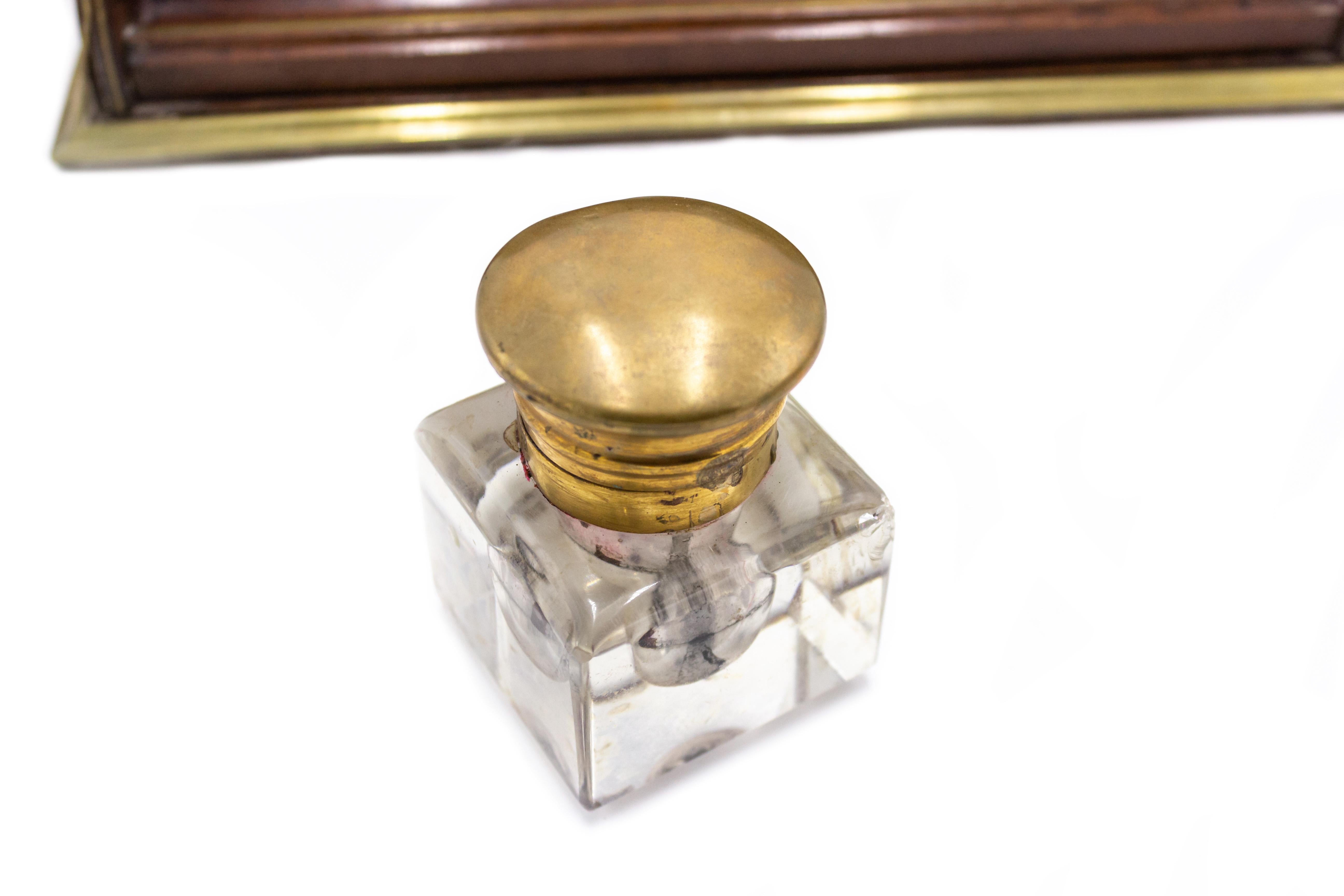 English Victorian mahogany and brass inlaid trim double inkwell with crystal wells having copper top lids and letter holder backrail.
 