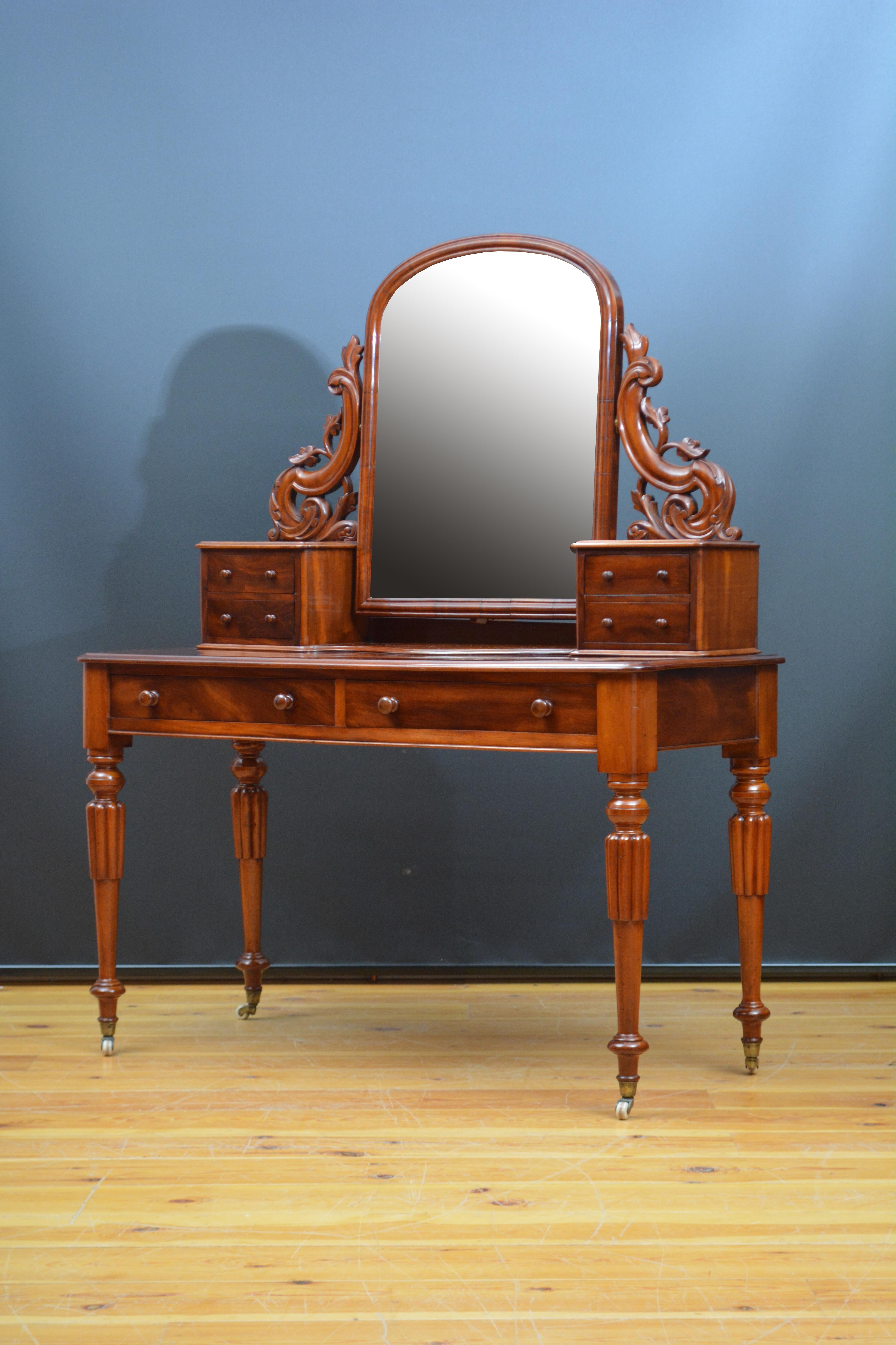 p0305 Very attractive antique, 19th century dressing table in mahogany, having original mirror, with some foxing and minor imperfections, in arched and moulded frame supported in finely carved uprights terminating in four small jewellery drawers and