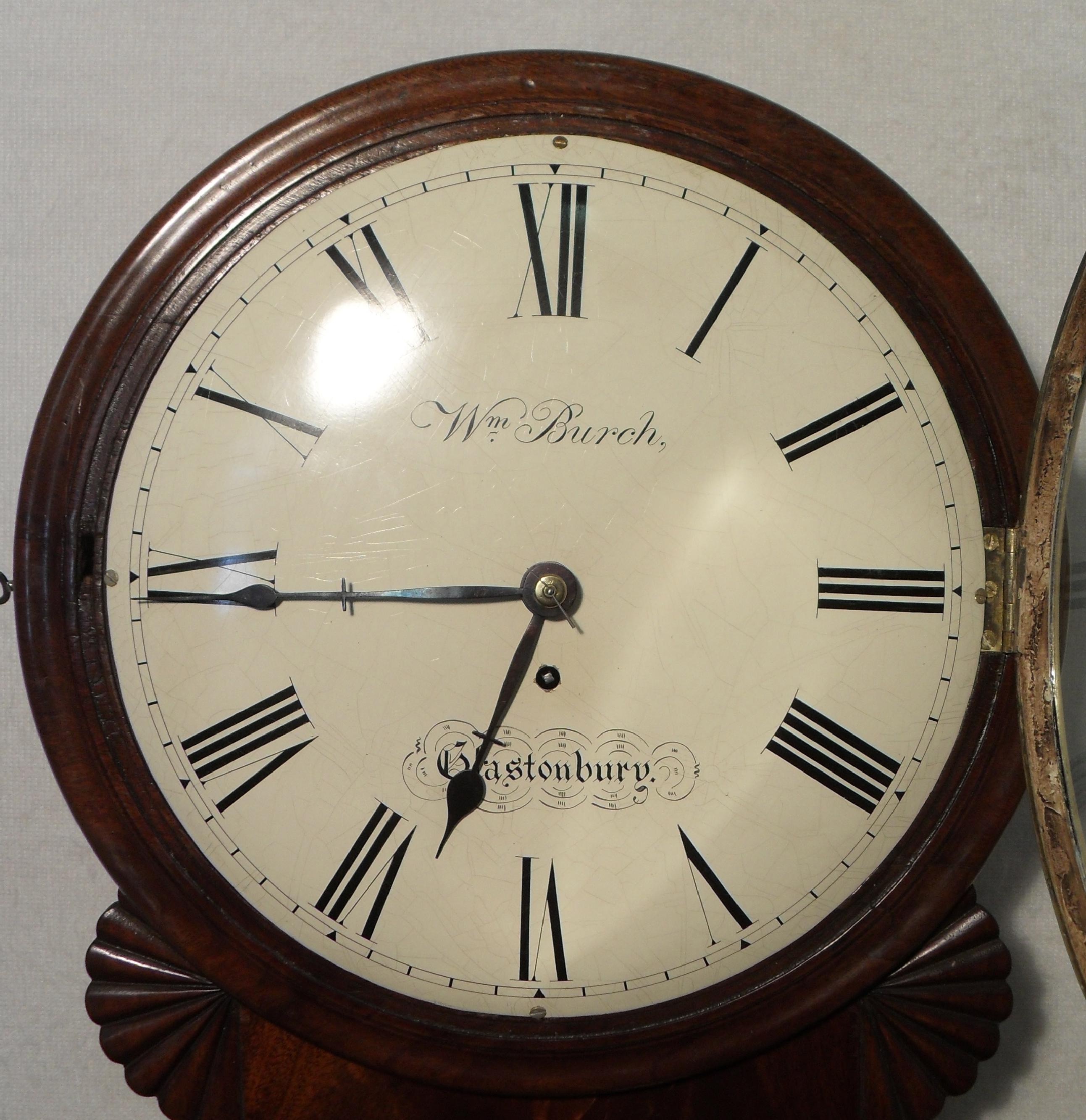 A good quality English mahogany drop dial wall clock timepiece with pendulum viewing window. The clock has a twelve inch painted dish dial and the movement is a single fusee with anchor escapement.

The dial has the makers name:-

William