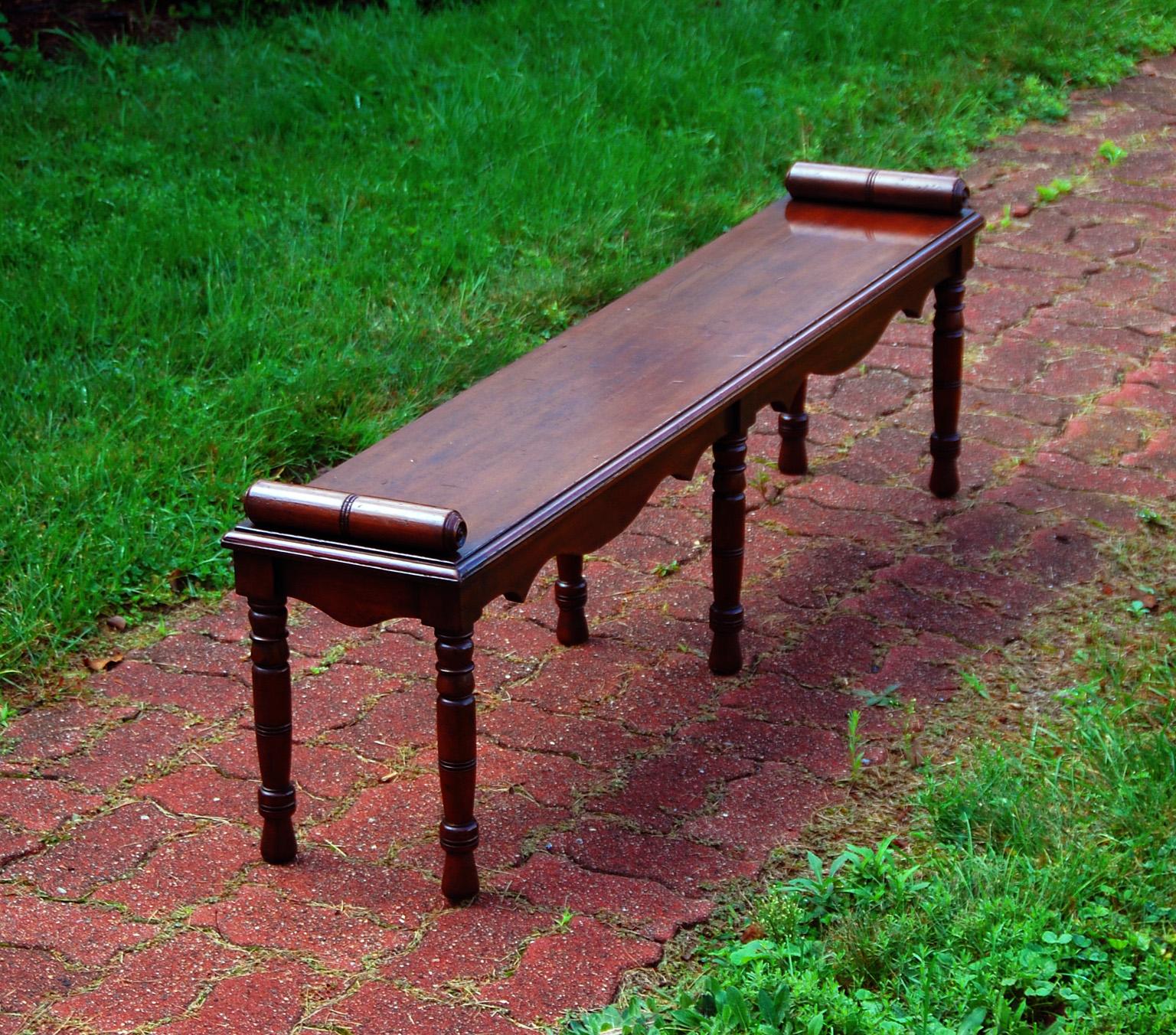 English Victorian mahogany six legged hall bench with shaped frieze, turned legs and roll ends. At 57 1/2