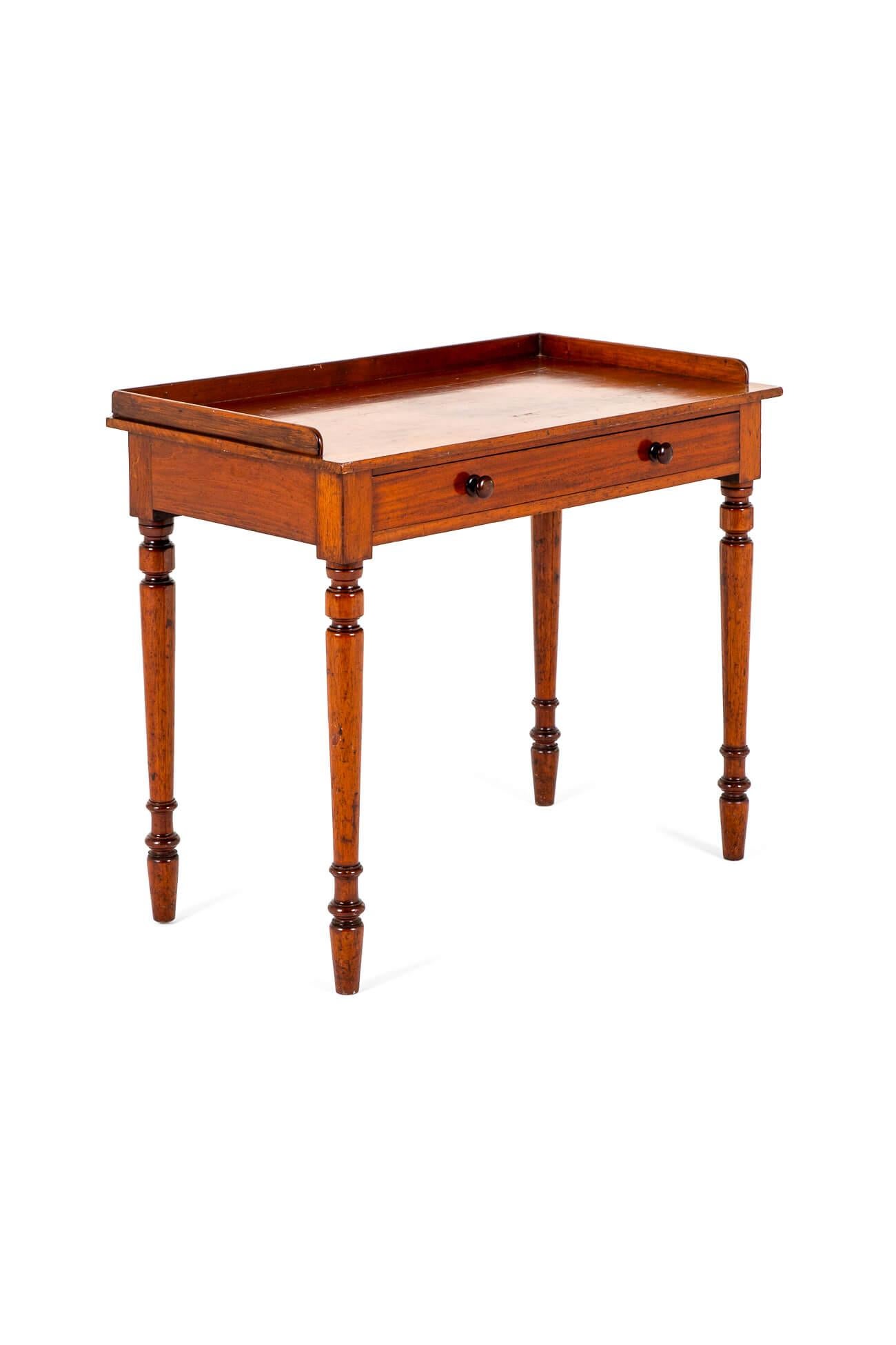 Table d'entrée victorienne simple en acajou avec un dossier à galerie de trois quarts.

La table est complétée par un seul tiroir à frise lisse avec des poignées à boutons d'origine.

Elle repose sur quatre pieds tournés légèrement effilés.

Dans un