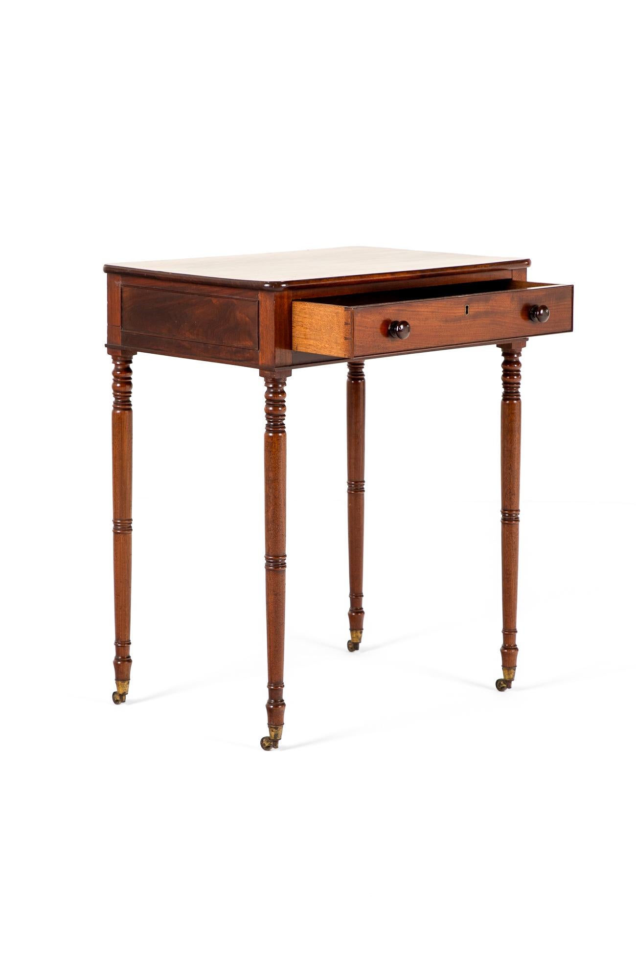 Espléndida mesa auxiliar victoriana de caoba labrada con un fino borde moldeado en la parte superior.

La mesa tiene un cajón con friso en el frente con un escudo de latón y un cajón ficticio en el reverso con tiradores torneados en cada uno.

Sobre