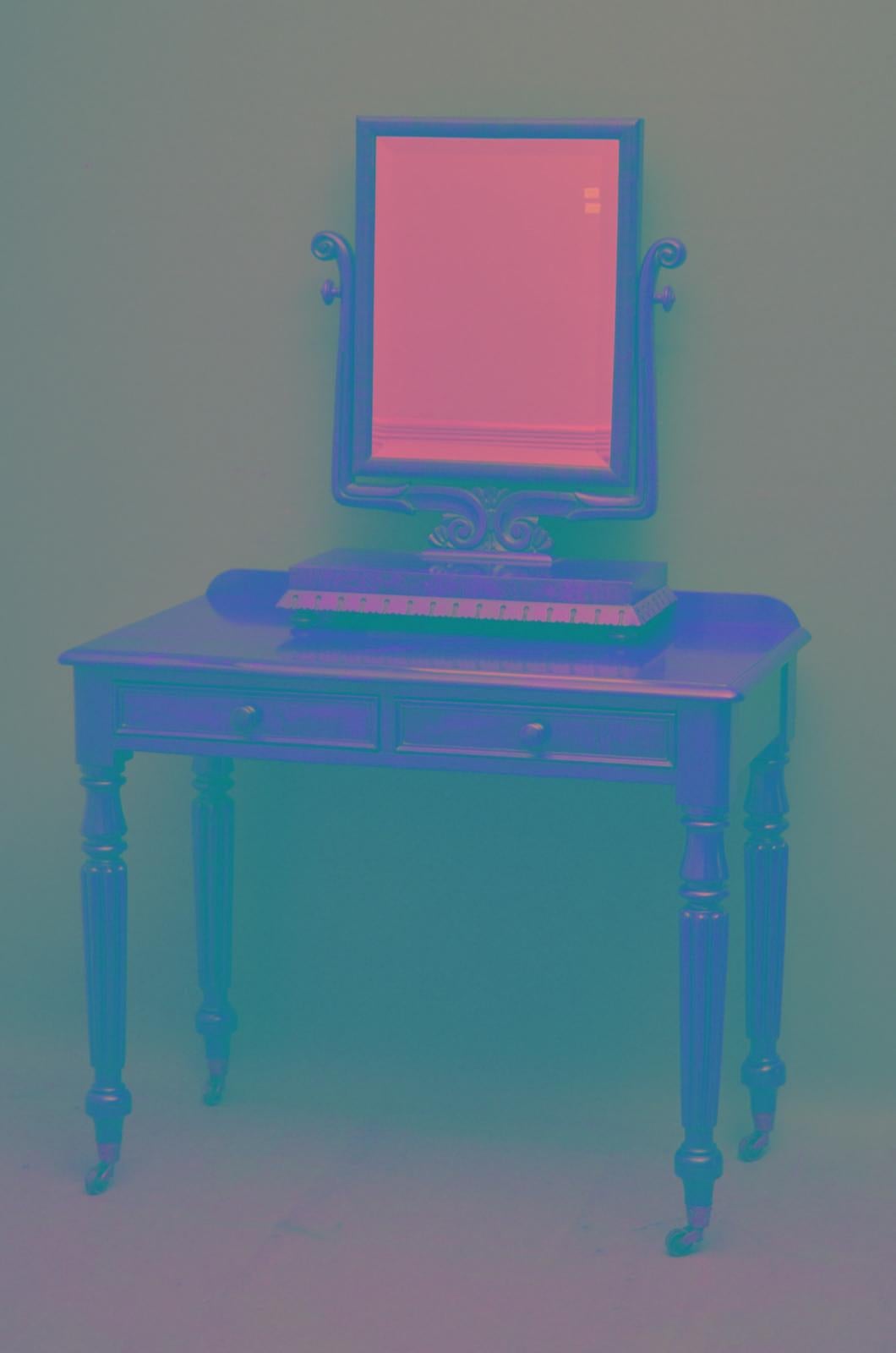 J00 Elegant Victorian mahogany dressing table / side table, having shaped upstand to figured mahogany top and 2 mahogany line drawers fitted with original turned knobs, standing on turned and fluted legs terminating in brass castors. This antique