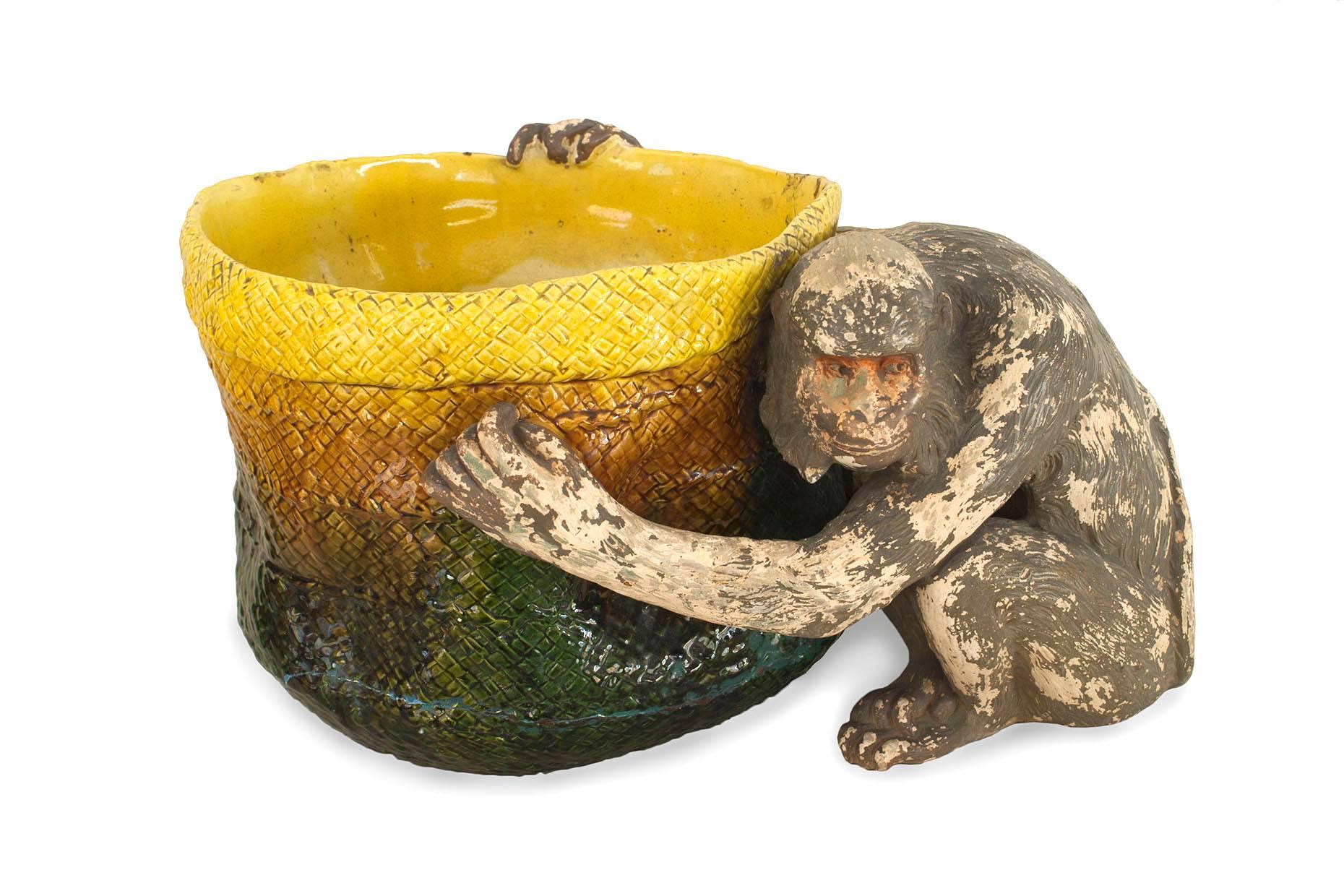 English Victorian (Majolica) porcelain green and yellow basket form jardiniere being held by a seated monkey figure (stamps: BRETBY ENGLAND)
