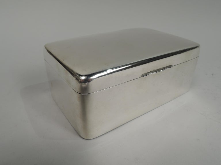Victorian sterling silver box. Made by Arthur & John Zimmerman in Birmingham in 1899. Rectangular with straight sides and curved corners. Cover hinged with gently curved top and double scroll tab. Box interior cedar lined and partitioned. Box