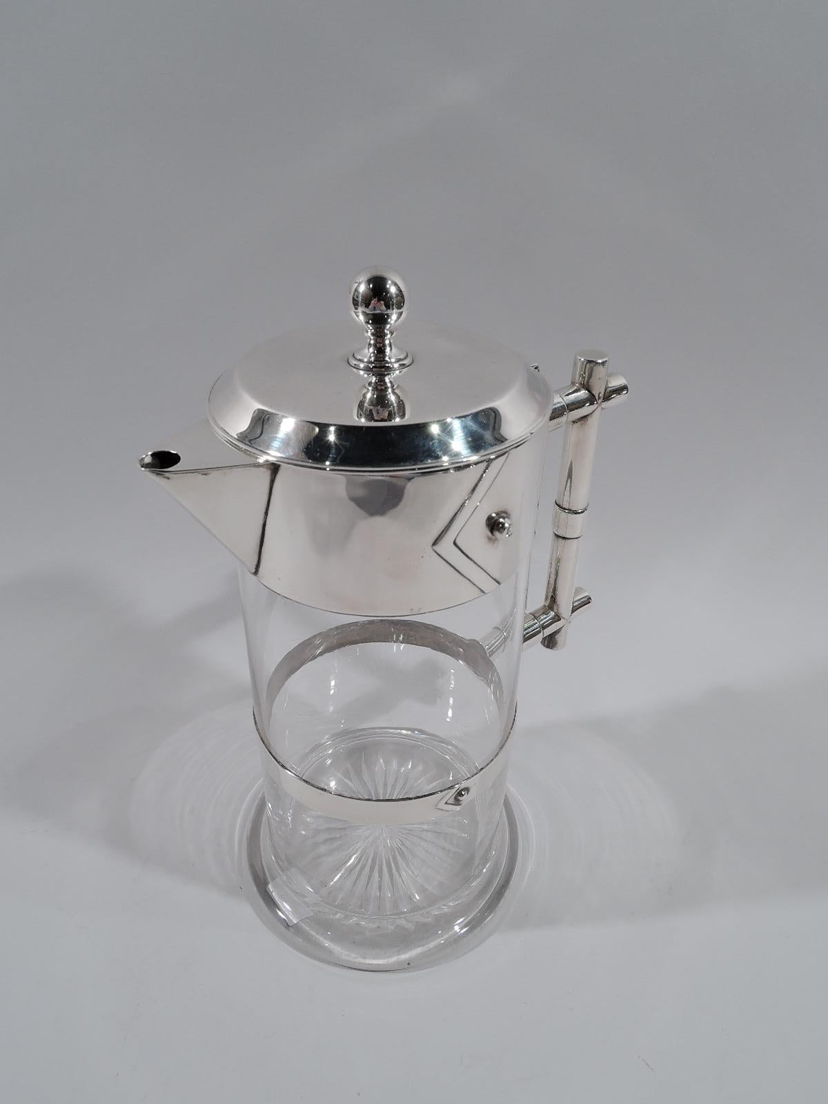 Victorian modern sterling silver and glass decanter. Made by Edgar Finley & Hugh Taylor in Birmingham in 1884. Clear glass cylinder on round and spread base. Flat girdle with applied chevron and stud. Rim collar same with triangular spout. Cover