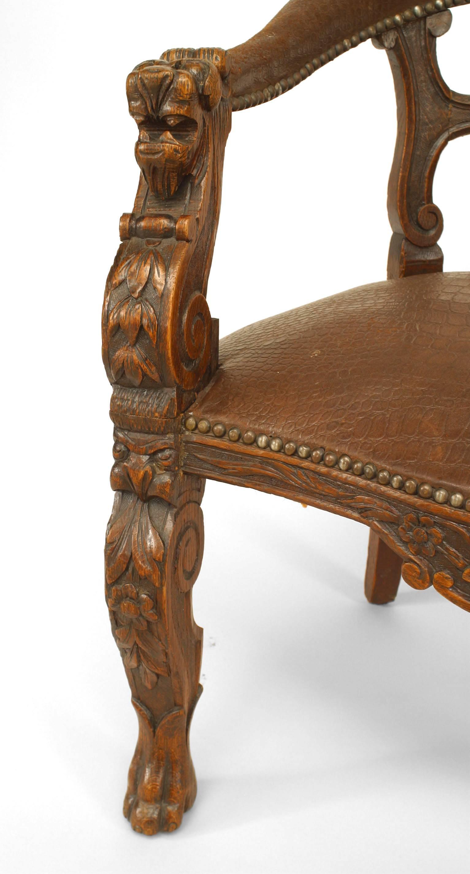 English Victorian oak round open back character armchair with carved heads on arms and dark brown leather upholstered seat and back rail (similar to Inv. #044315).
 