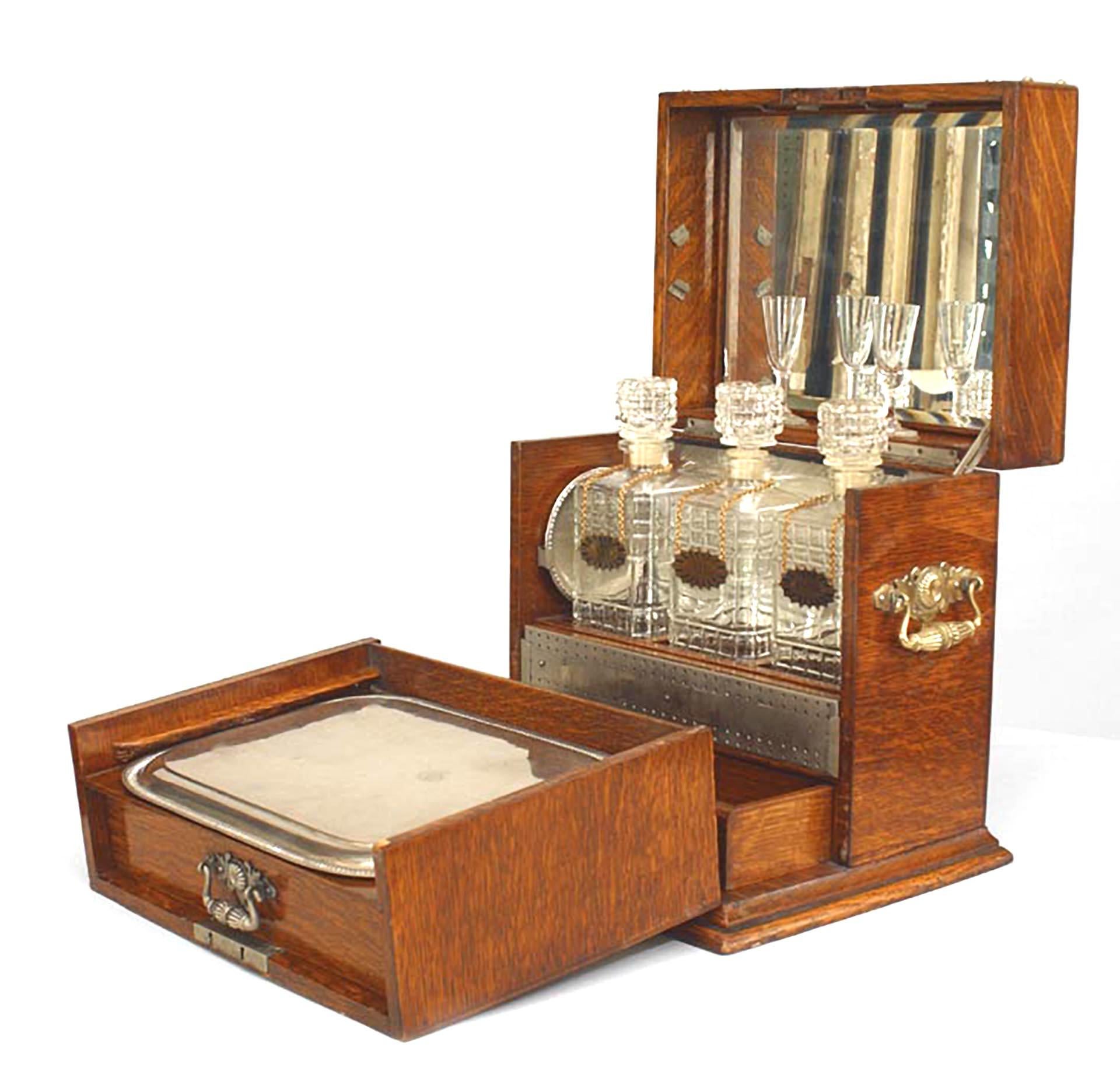English Victorian oak traveling tantalus box with brass filigree trimmed corners, handles, and trim (silver plate tray & 2 coasters, 2 cordial glasses, 3 pressed glass bottles).
 