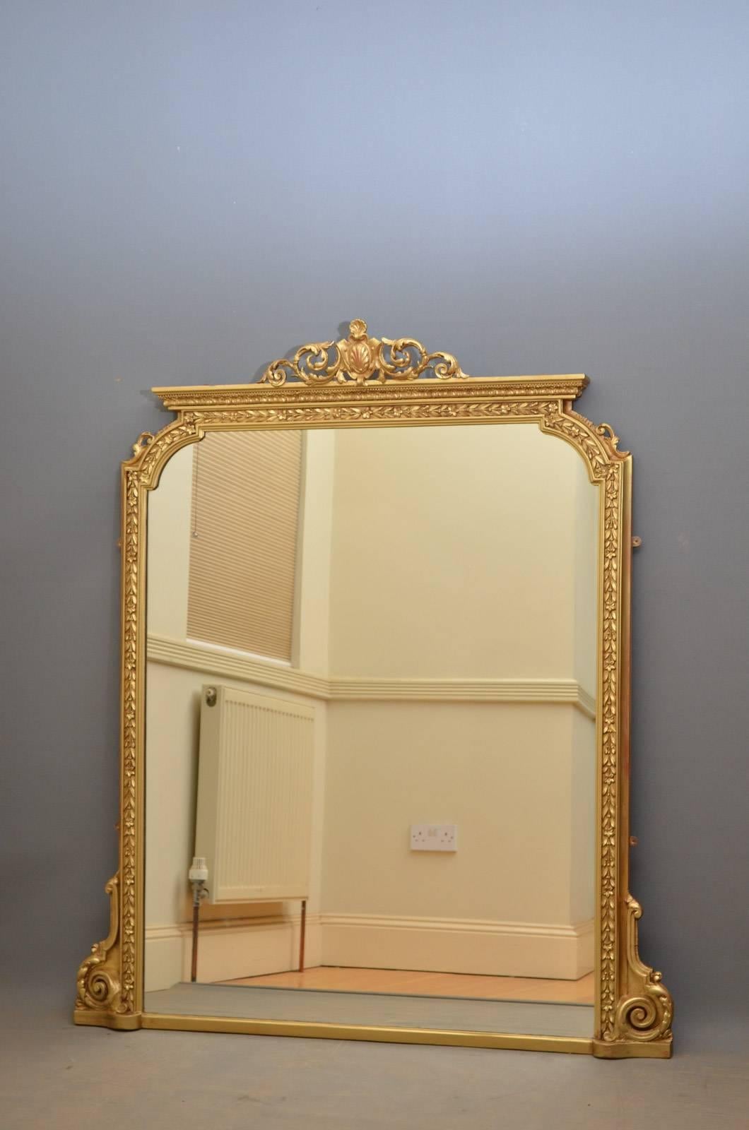 K0338 Large Victorian gilt wall mirror, having scroll cartouche to centre and original mirror plate with some foxing in finely decorated frame all flanked by foliage scrolls to base. This antique mirror has been refinished and is in home ready