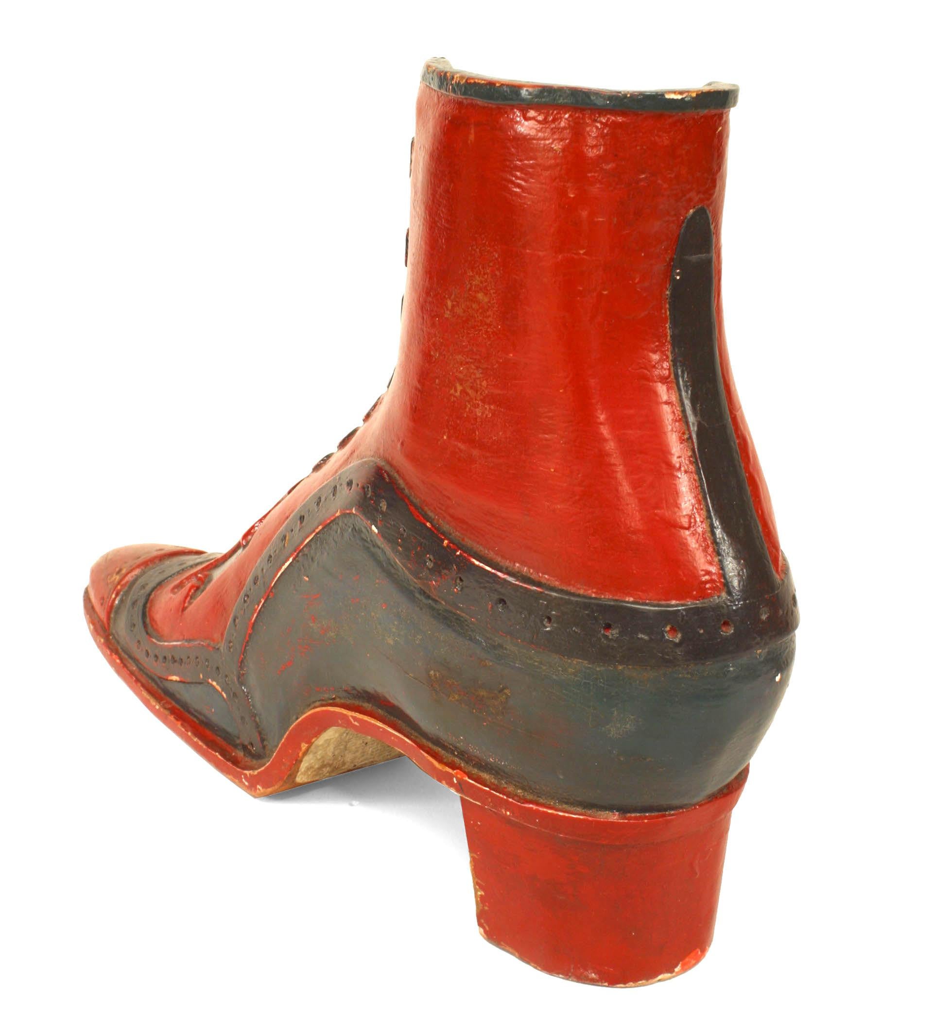 Insegna per calzolaio vittoriana in rosso e blu, dipinta e decorata in legno intagliato.
    