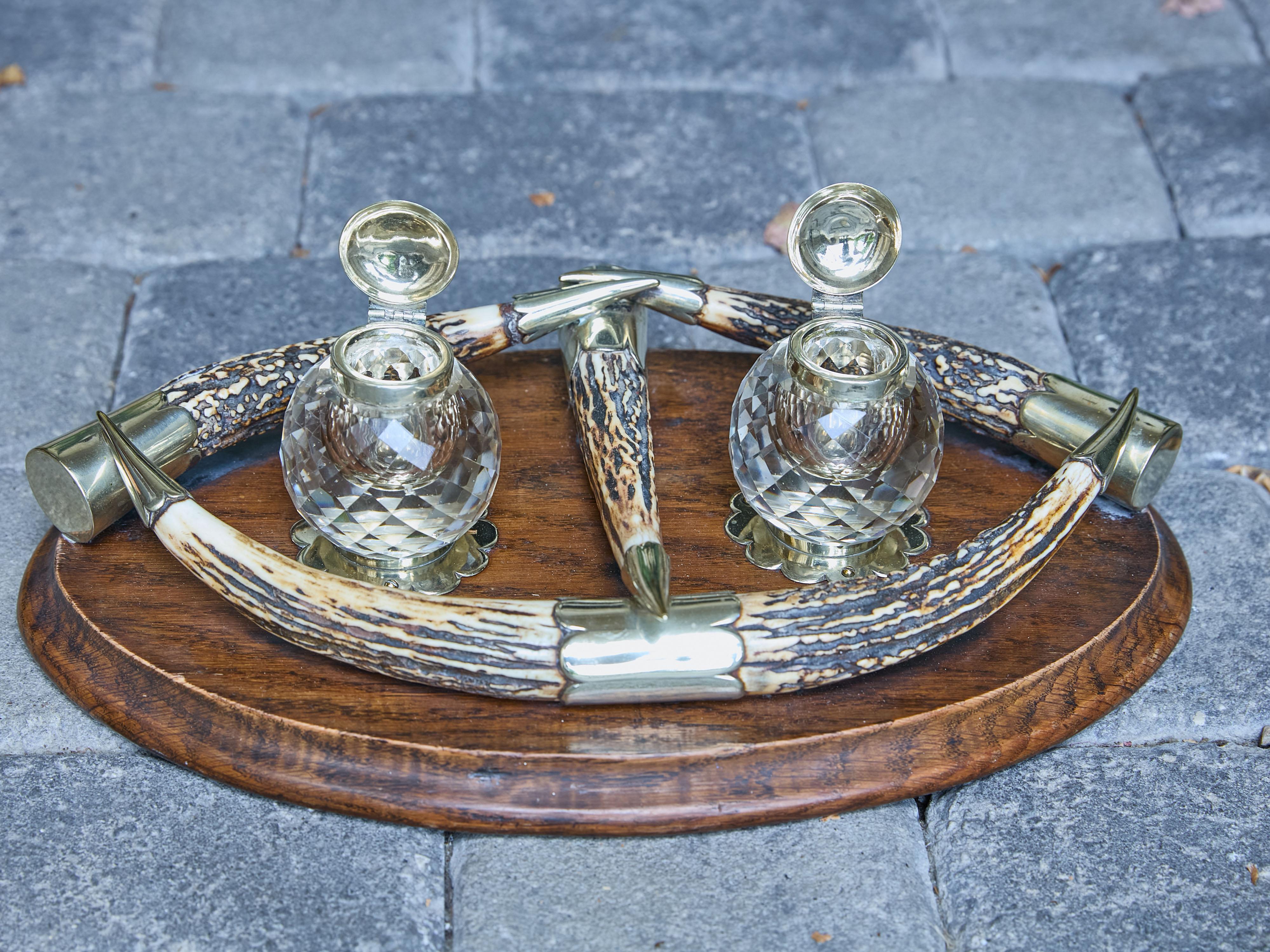 An English Victorian period inkwell from the 19th century with antlers, silver plate and crystal bottles. This English Victorian period inkwell from the 19th century effortlessly combines rustic charm with elegant sophistication. Resting on an