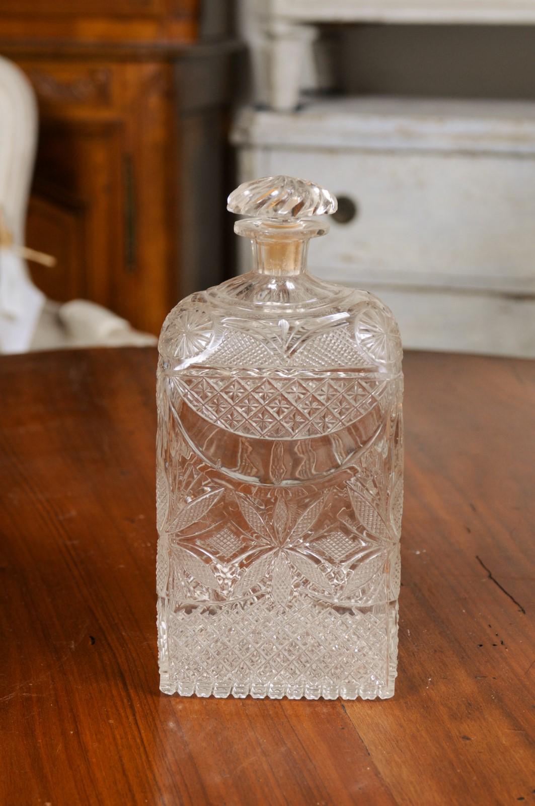 An English Victorian period glass vanity bottle from the 19th century, with etched décor. Created in England during the Victorian era, this vanity bottle features a twisted stopper resting on an abundantly adorned body. Showcasing diamond motifs