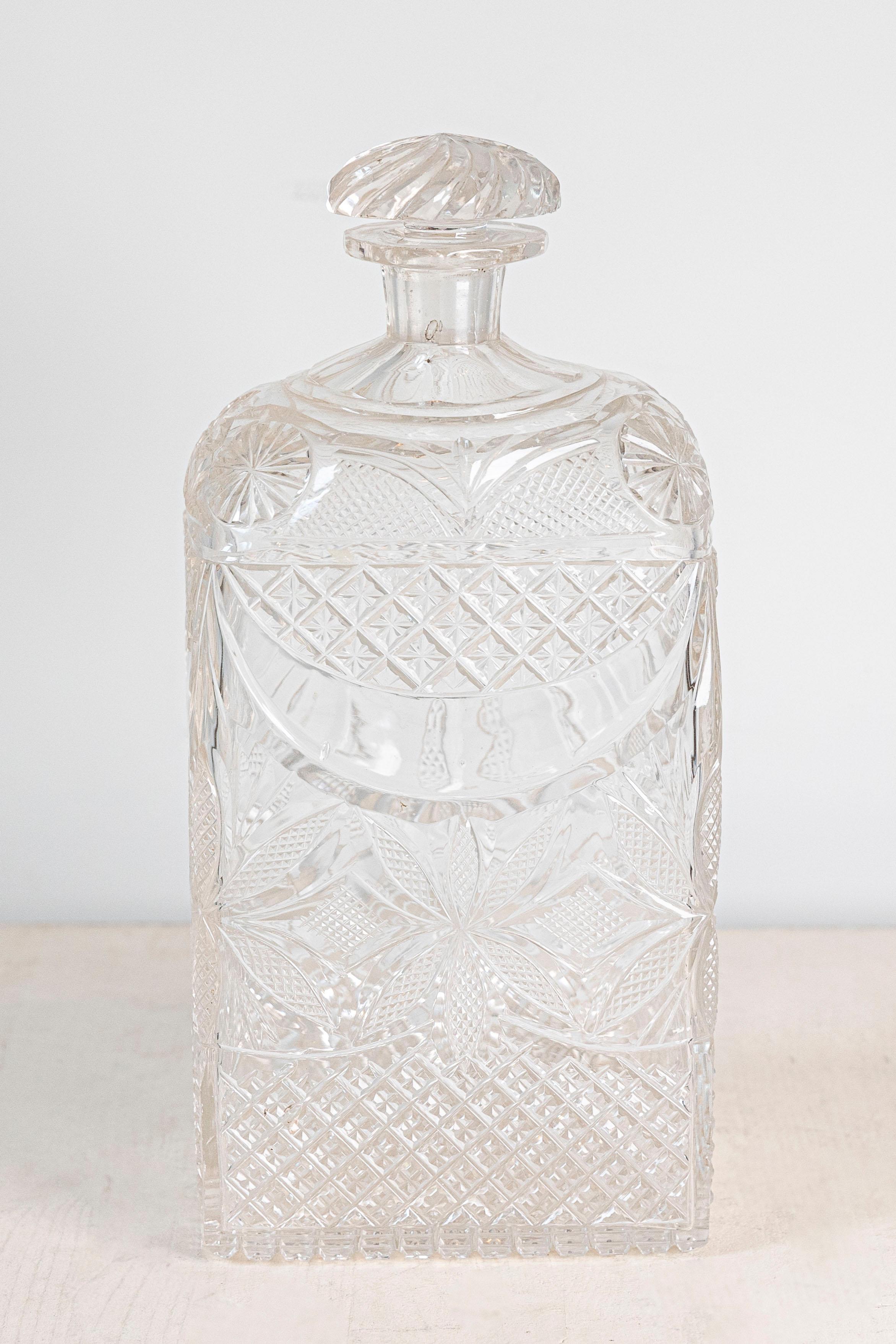 An English Victorian period glass vanity bottle from the 19th century, with etched décor. Created in England during the Victorian era, this vanity bottle features a twisted stopper resting on an abundantly adorned body. Showcasing diamond motifs