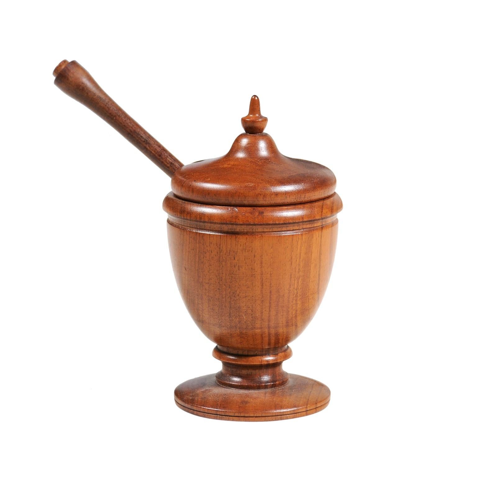 An English Victorian period turned wood spice holder from the 19th century with finial-topped lid and petite mixing tool. Created in England during the reign of Queen Victoria, this wooden spice holder charms us with its petite proportions and