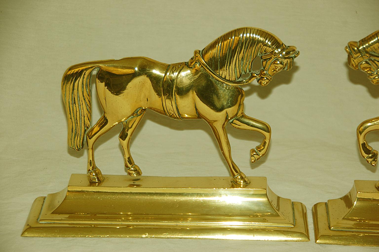 English Victorian period large pair of cast brass doorstops. These heavy doorstops are quite stable and are a true pair with a right facing and a left facing horse each on a substantial base, mid-19th century.