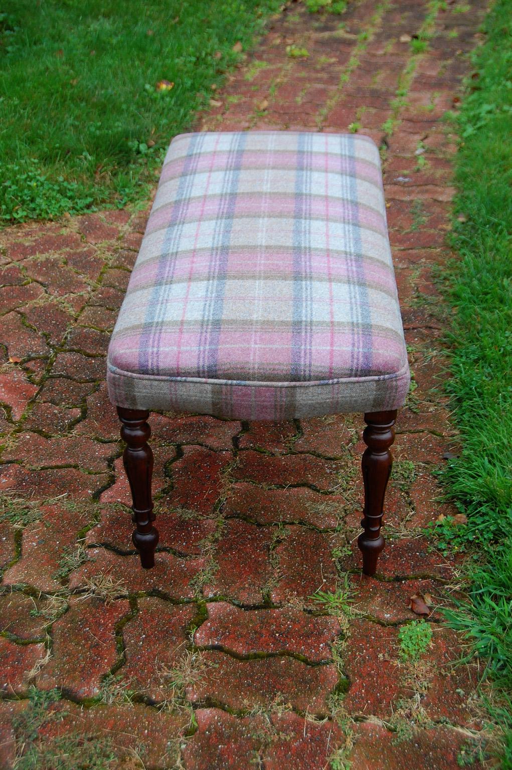 English Victorian period rosewood upholstered bench with tapered, turned and carved legs. The top is shaped with a slight bow detail at each end; the fabric is a wool plaid in pinks and greys and has just recently been upholstered in Scotland. At 42