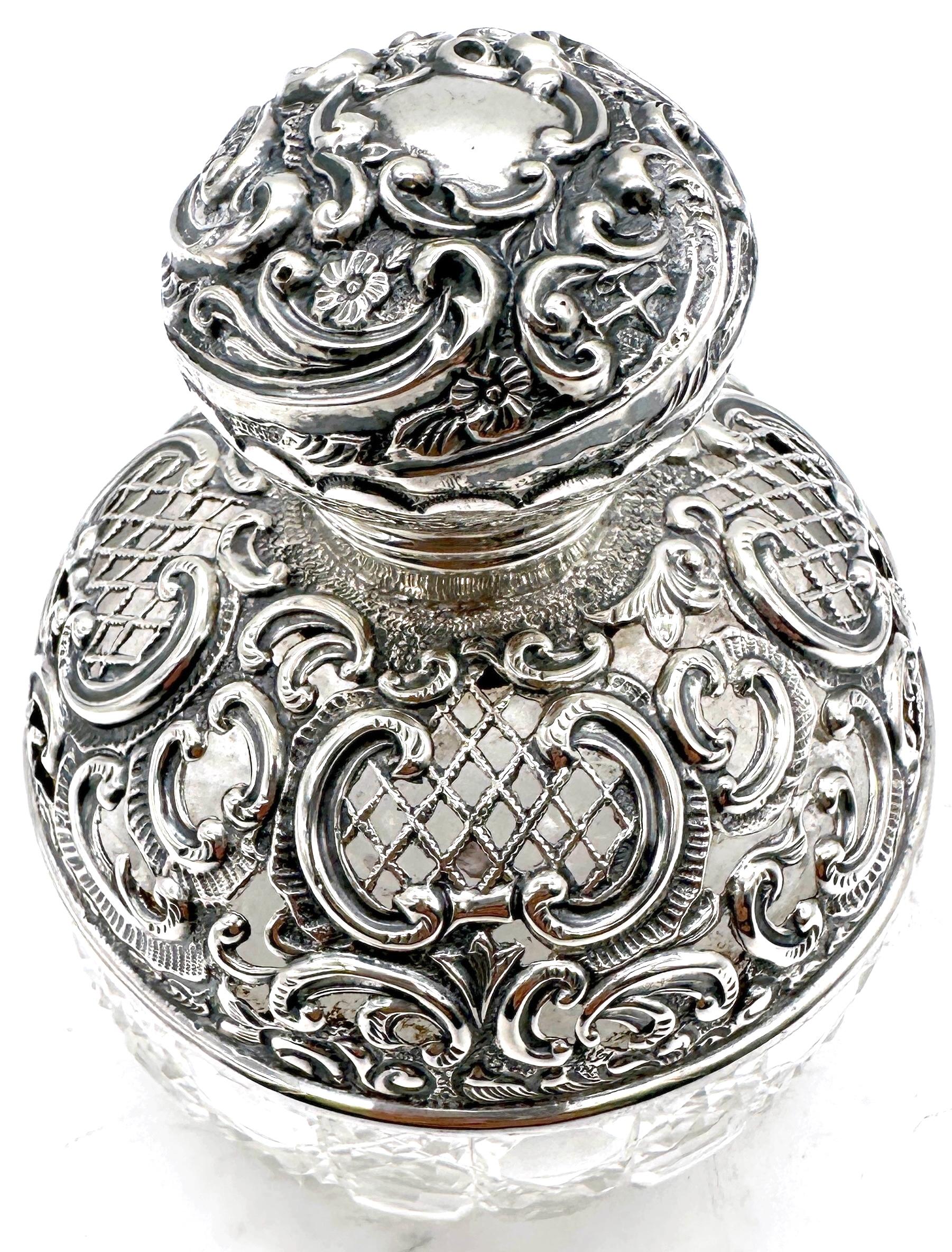 English Victorian Pierced Sterling & Cut Glass Perfume Bottle, Sheffield, 1901

This exquisite Victorian pierced sterling silver and cut glass perfume bottle, crafted by Walker & Hall in Sheffield, England, in 1901, is a stunning example of fine