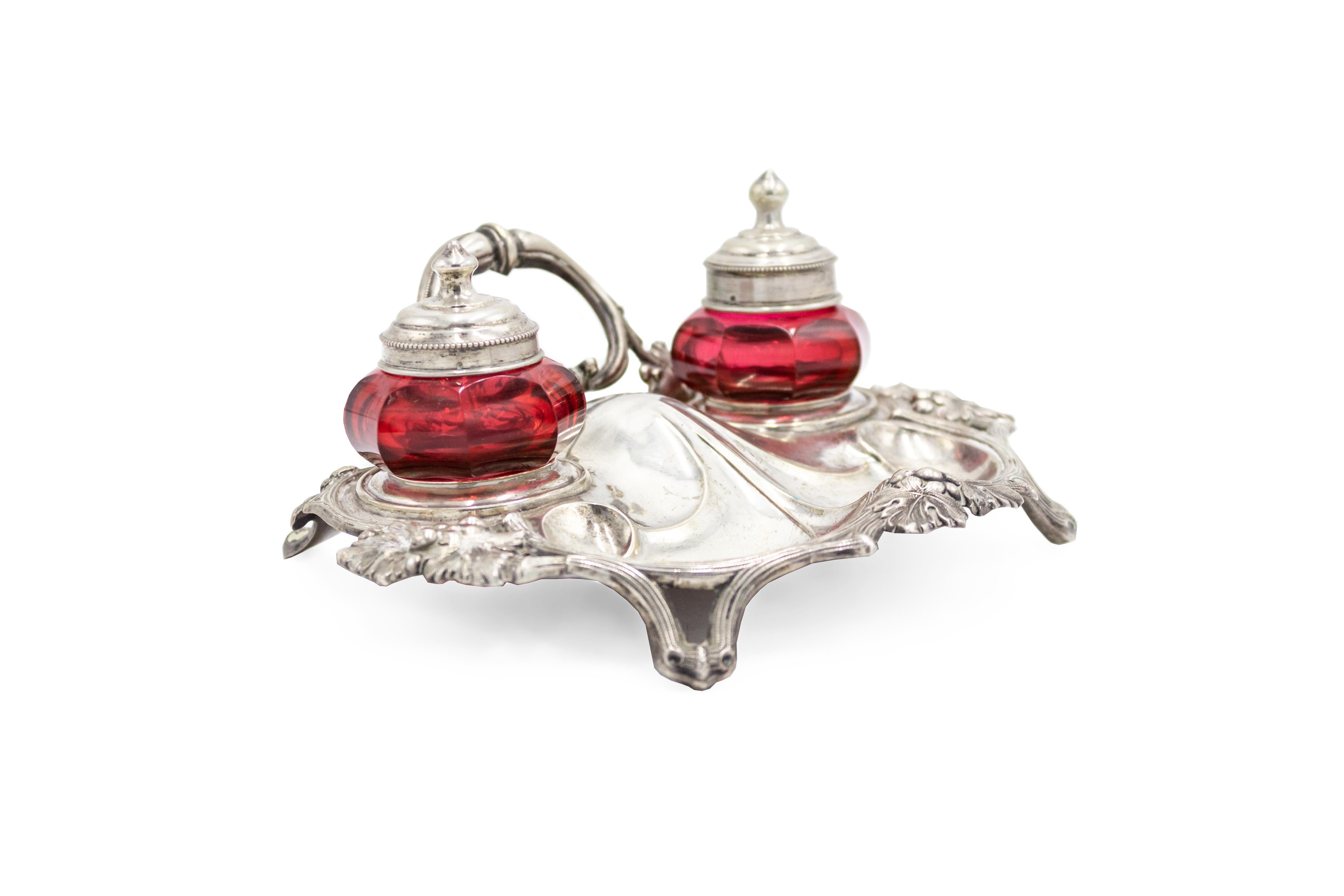 English Victorian silver plated inkwell with 2 cranberry glass wells and back handle.
 
