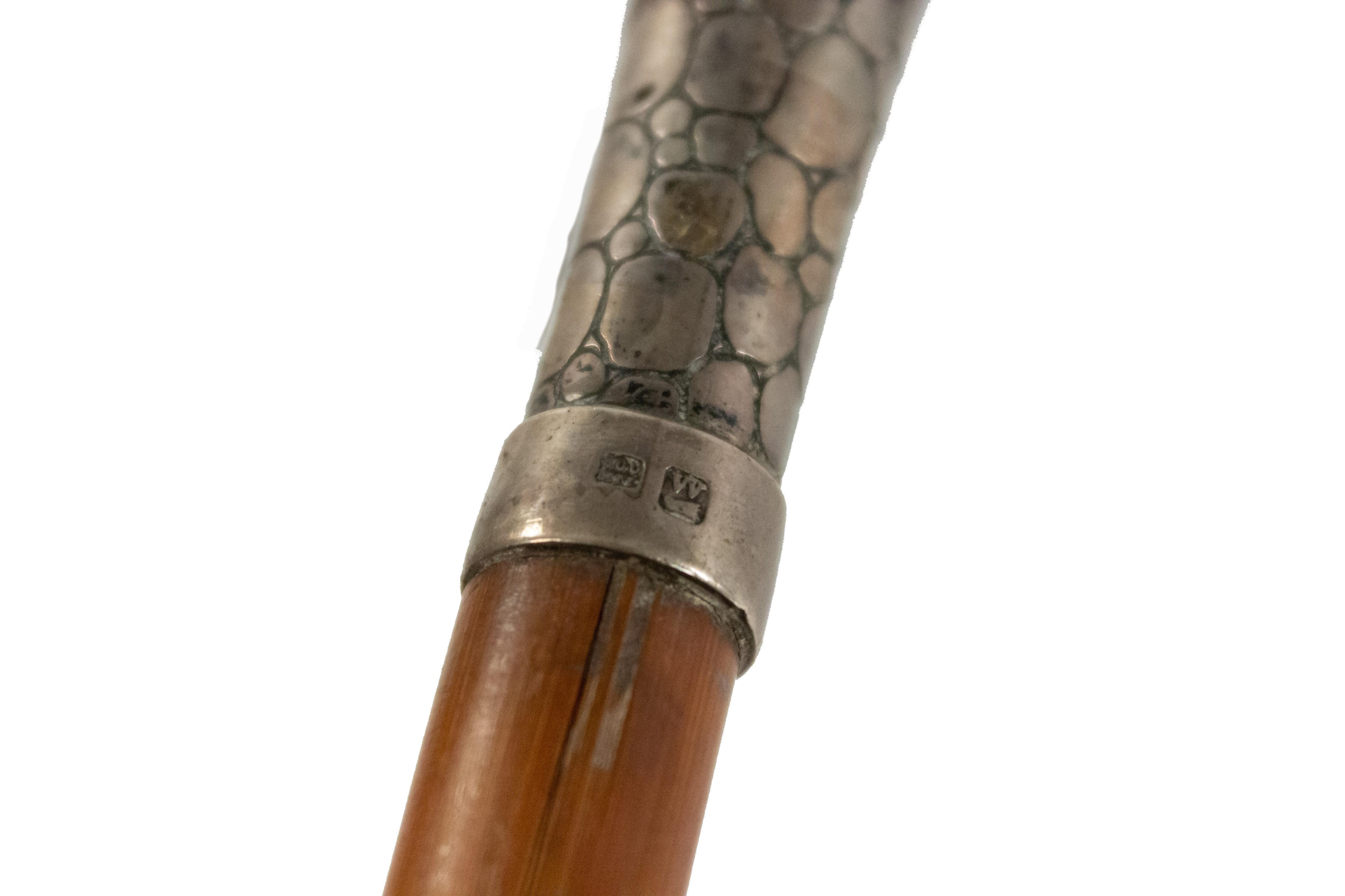 English Victorian-style simple wood cane with silver skin design handle with hallmarks at base.