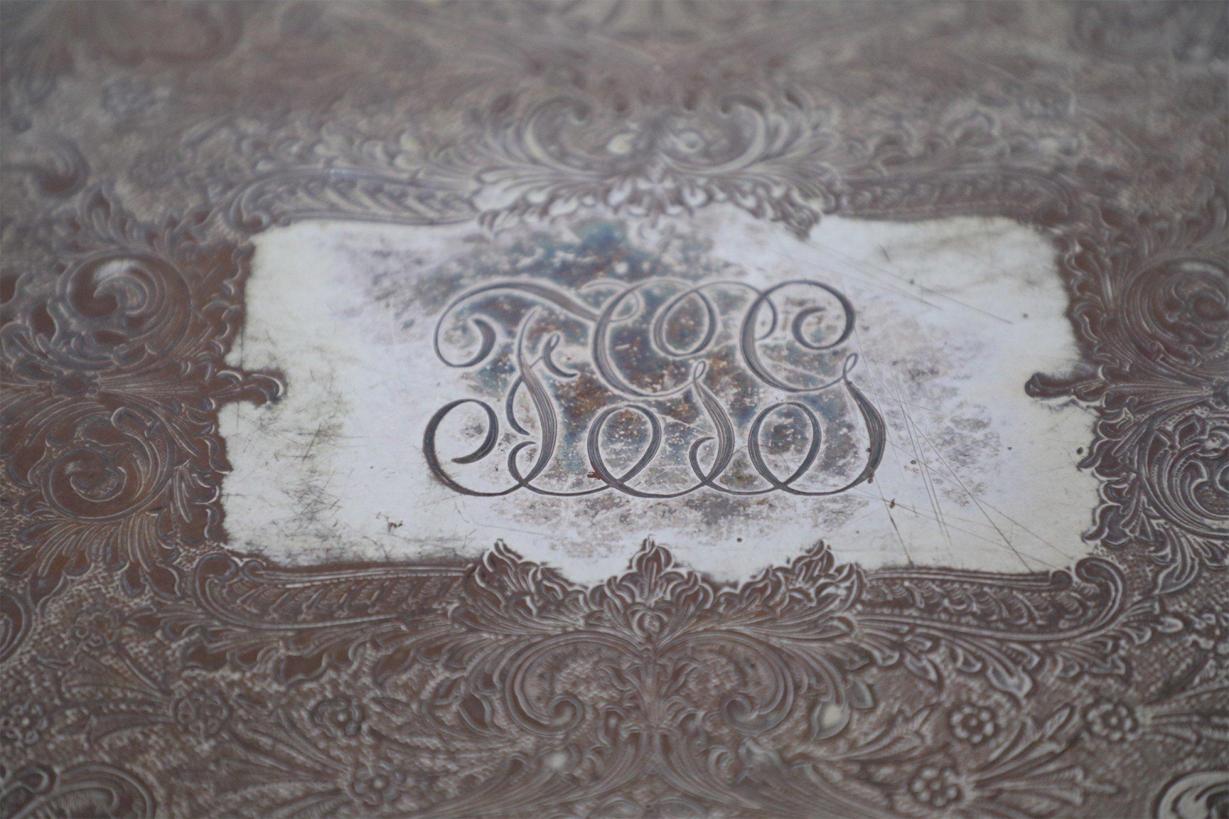 English Victorian rectangular silver plate tray with ornate border and handles and an engraved surface with a central monogram.
 
