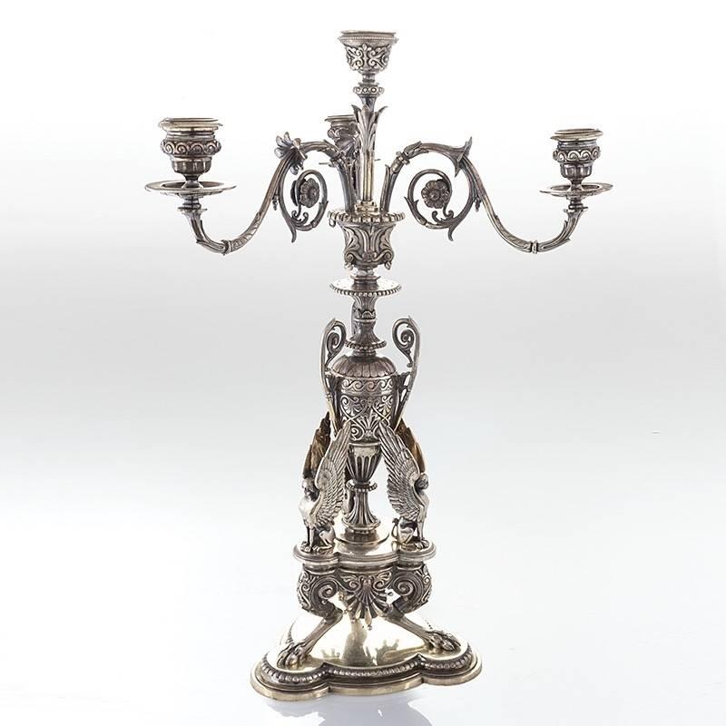 A suite of three English Victorian silver-plated suite by Elkington & Co. The suite comprises a pair of four-light candelabra and an epergne. Each candelabra is decorated with three sphinxes that sit atop a splayed paw footed platform. The stem and