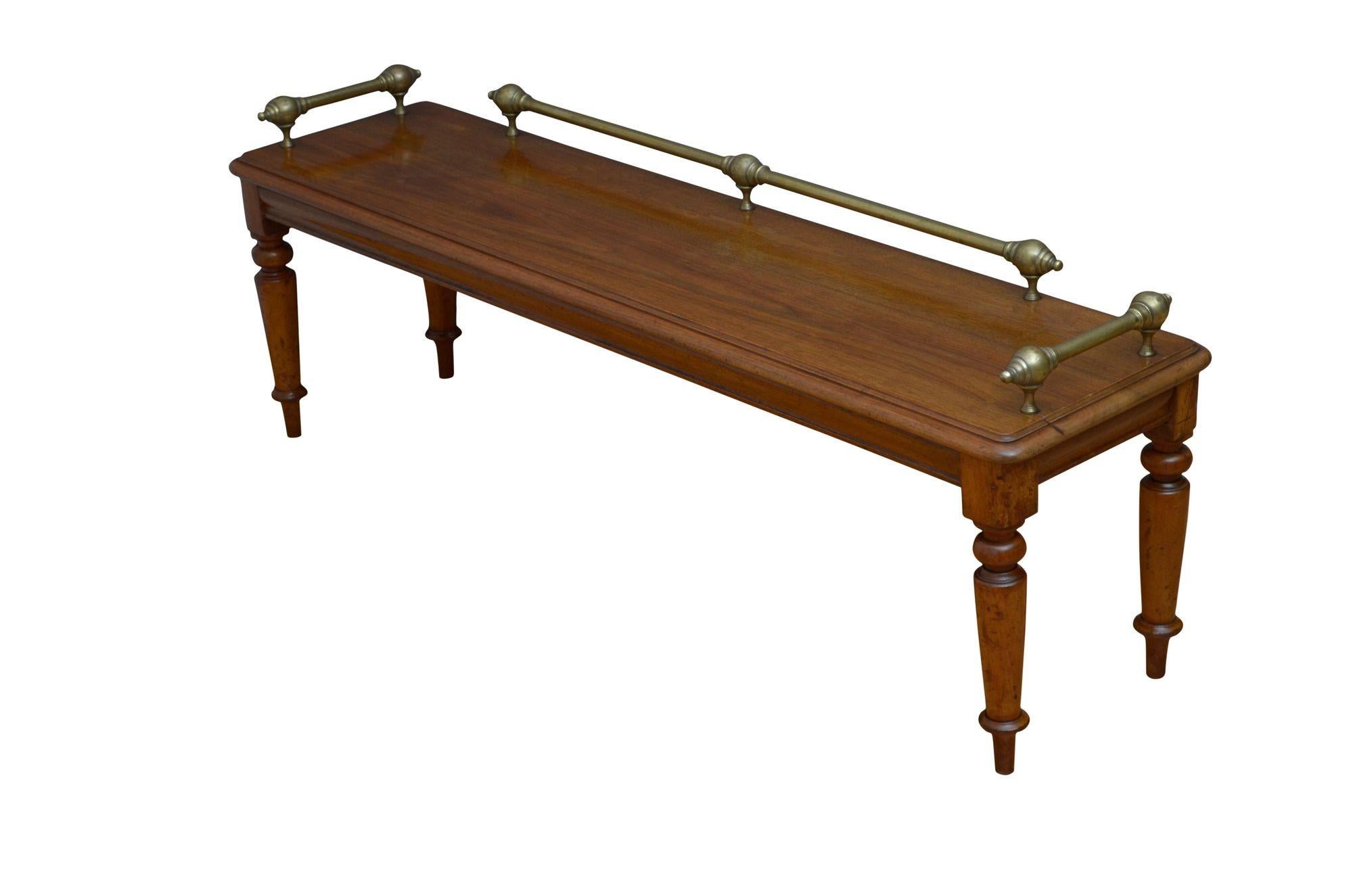 K0612 A superb Victorian hall seat in walnut, having decorative brass rails to the solid and figured walnut seat above shallow and shaped frieze, all standing on four turned and tapered legs. This antique bench oozes quality and it retains its