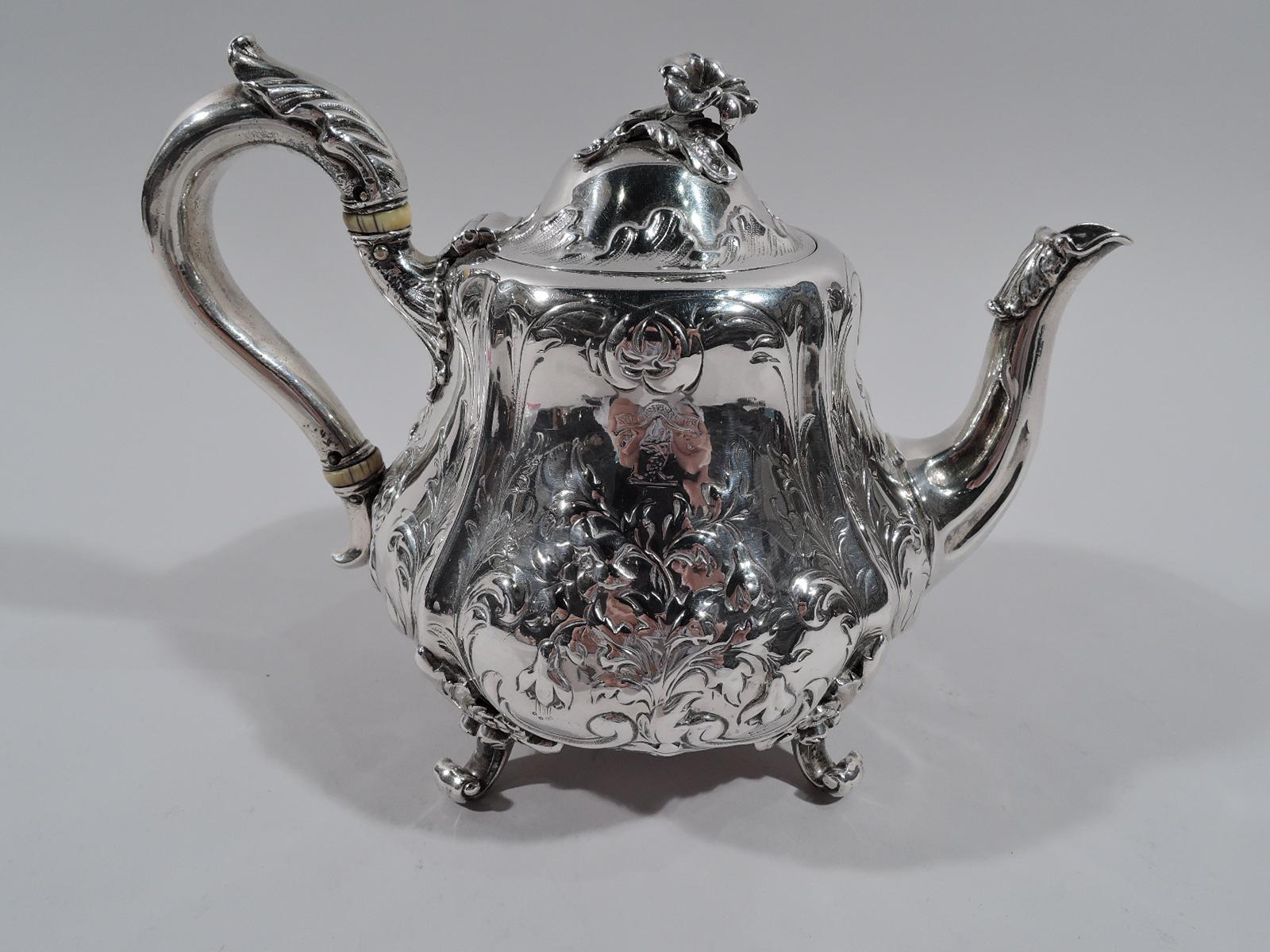 Victorian sterling silver teapot. Made by Hunt & Roskell in London in 1857. Round and bellied with leaf-capped s-scroll spout and leaf-capped high-looping handle. Cover domed and hinged with flower finial. Loose flowers on body as well as engraved