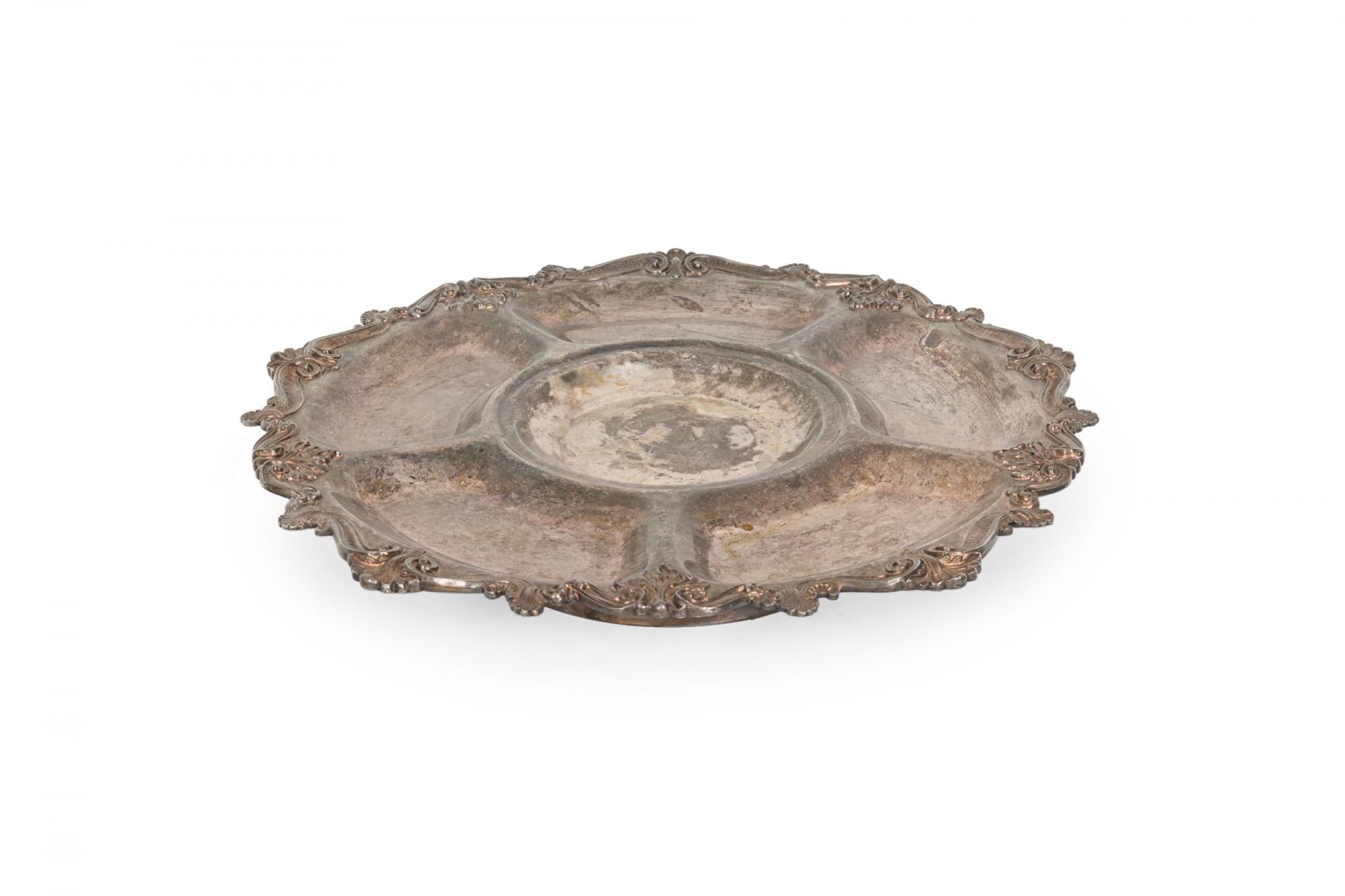 English Victorian-style silver plated lazy susan serving tray with five sections surrounding a central bowl with ornate edging on a rotating pedestal.

Heavy tarnish.