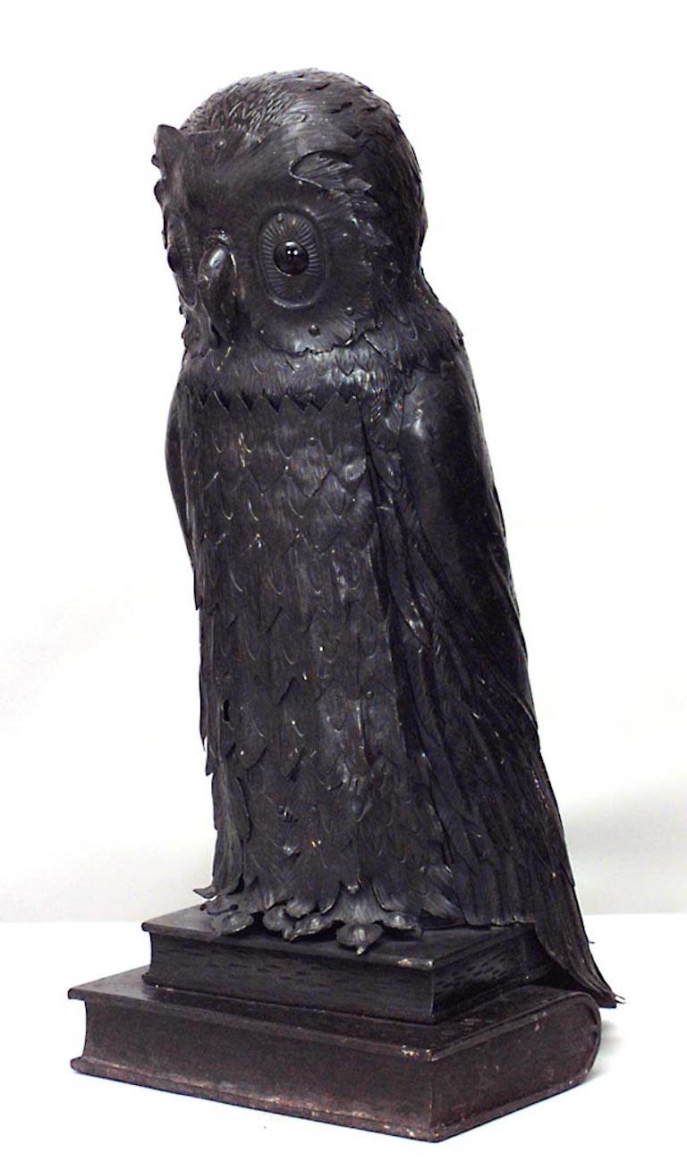 English Victorian metal table lamp of owl standing on 2 books with door in front.

