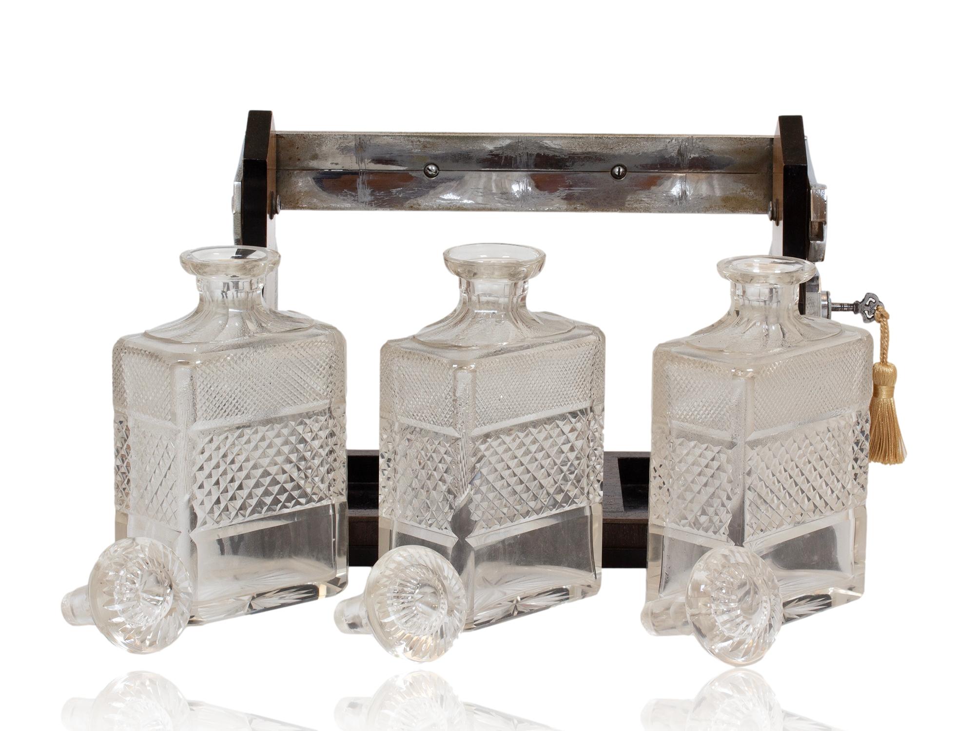 FREE WORLDWIDE SHIPPING 

Beautiful Coromandel and Satinwood Design 

From our Tantalus collection, we are delighted to offer this superb Art Deco lockable decanter holder by to George Betjemann and Son.The Tantalus designed originally by George