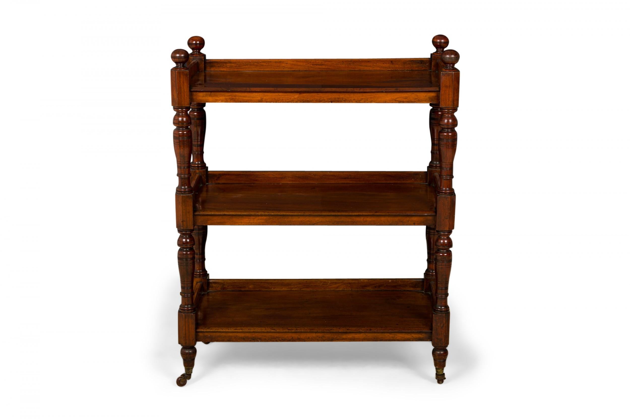 English Victorian (19th century) three-tier etagere / display shelf with three wooden rectangular shelves with low wooden galleries around three sides, supported at each corner by turned legs topped with ball finials and ending in small brass