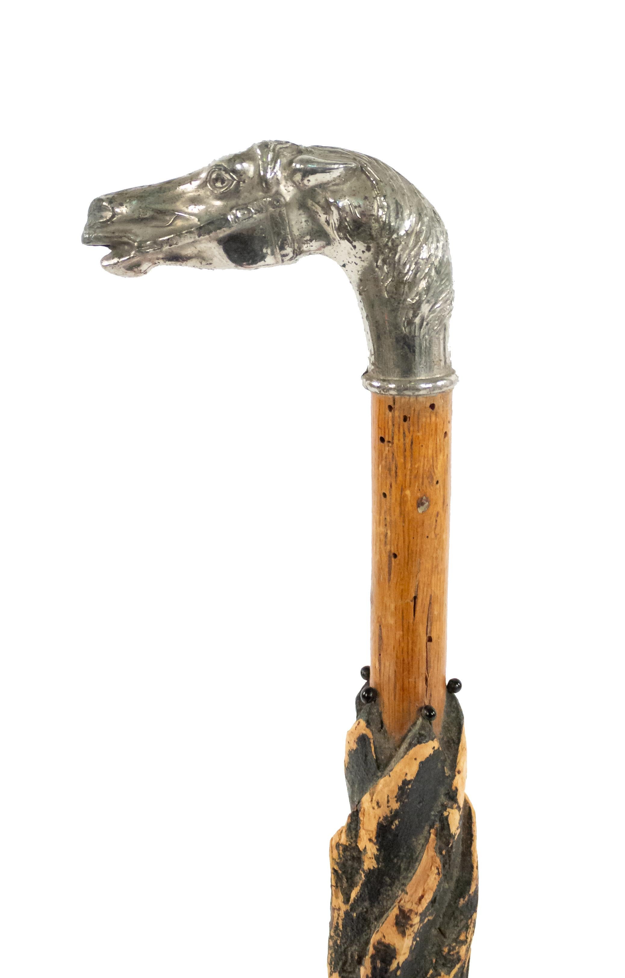 Englischer Stock im viktorianischen Stil mit geschnitztem Schirm und silbernem Pferdekopfgriff.
 