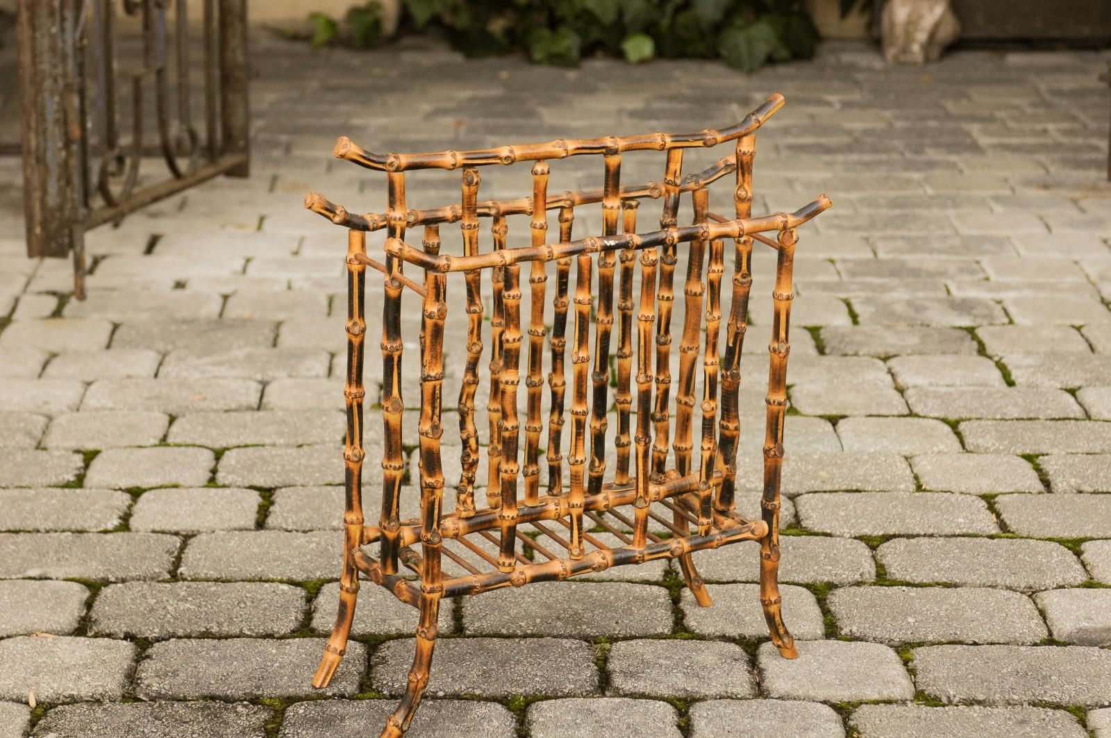 A vintage English mottled bamboo magazine rack from the mid-20th century, with chinoiserie influence. Born in England during the midcentury period, this bamboo magazine rack presents a stylish Silhouette, showing an undeniable chinoiserie
