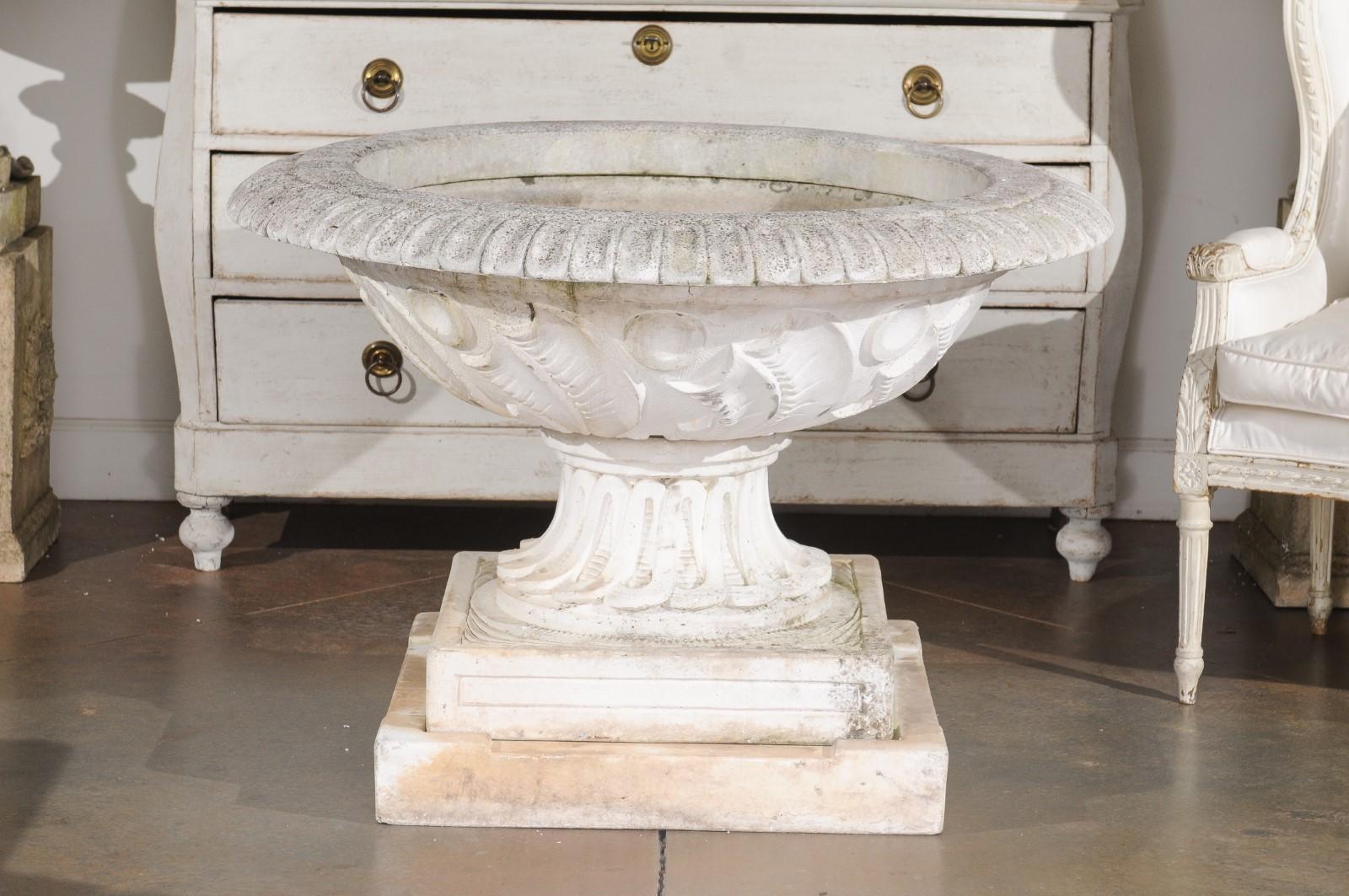 An English cast stone fountain from the 20th century, with scoop and foliage motifs. Created in England during the 20th century, this vintage cast stone fountain features a circular bowl adorned with a perfect rhythm of scoop motifs on the rim. The