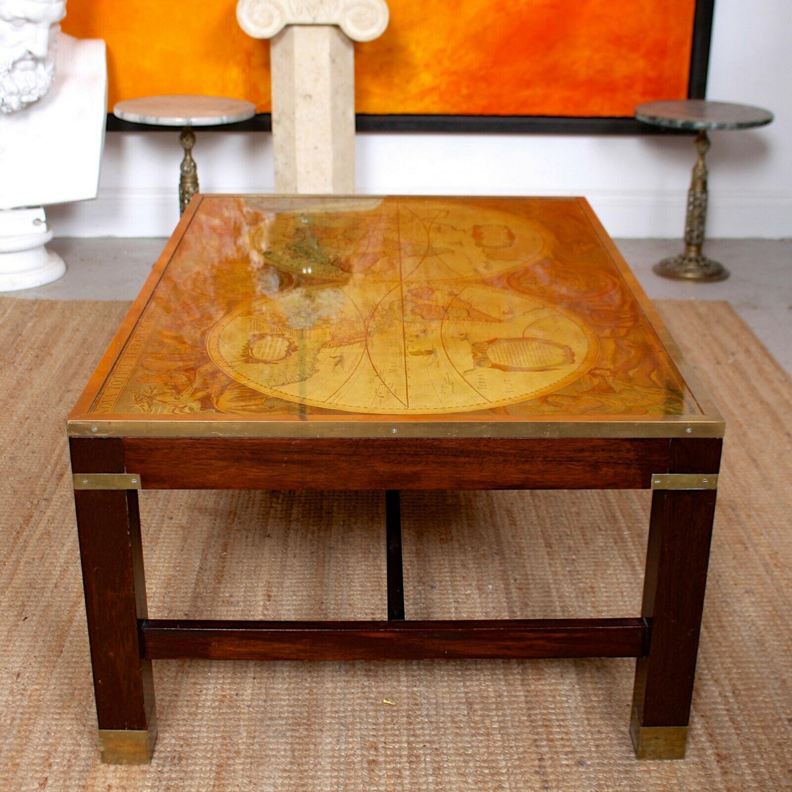 An impressive vintage glazed globe coffee table in the Campaign style.
The top with a glass topped enamel painted world map with brass trimmed edges and raised on a carved chamfered solid hardwood frame.
England, 20th century.