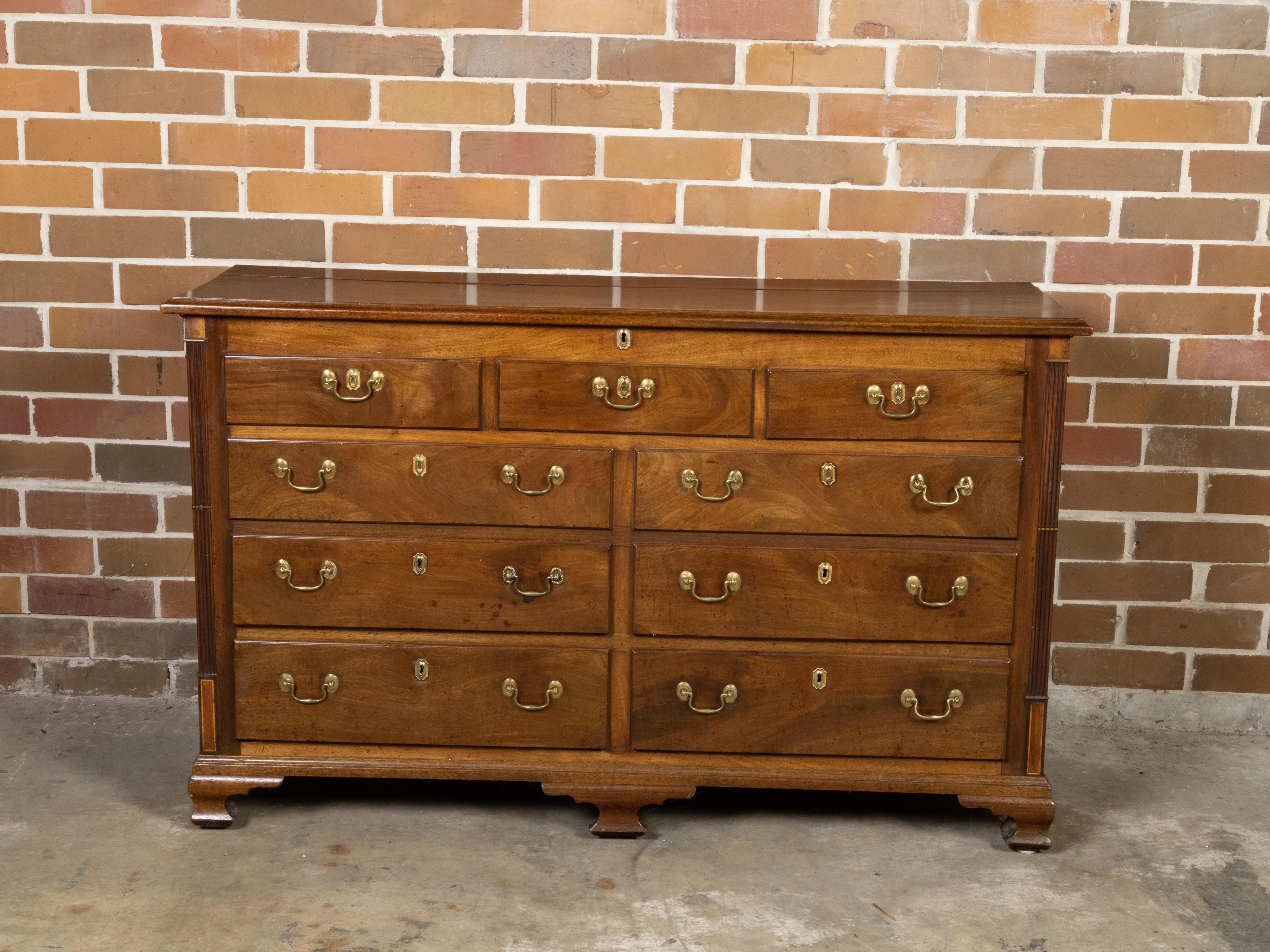 An English walnut flip top sideboard from the 19th century with faux drawers, four lower ones and reeded side posts. Created in England during the 19th century, this walnut sideboard is full of surprises! The piece features a rectangular flip top