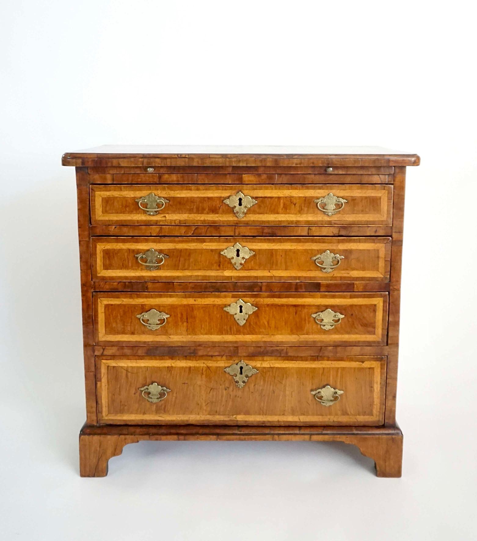 Eine feine und seltene circa 1730 Englisch frühen George II Periode kleine Skala Dressing oder Bachelor's Brust, die Nussbaum furniert Fall mit bookmatched Viertel furniert und Federband oben mit einem geformten Rand über eine Bürste gleiten und