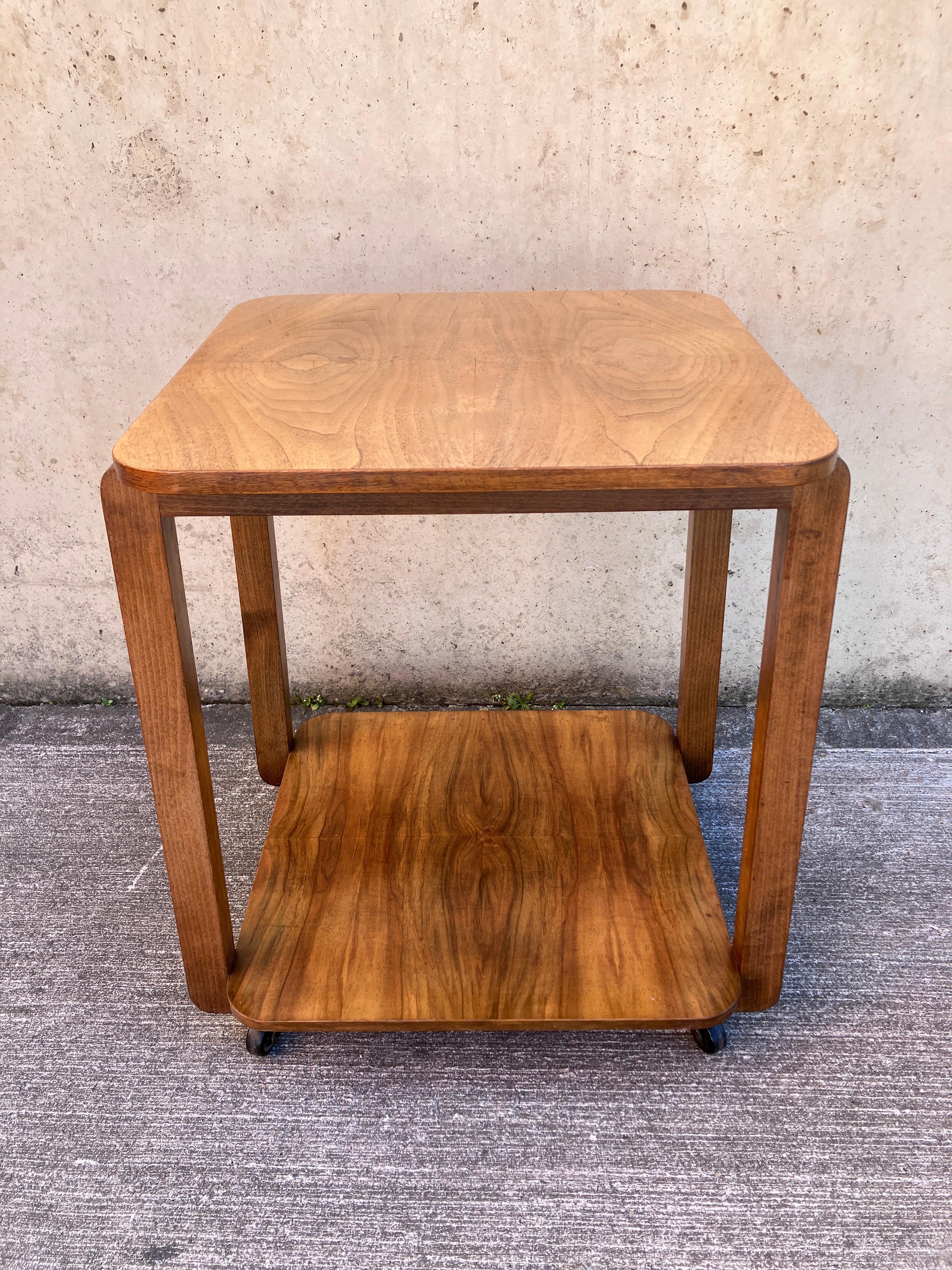 Magnifique chariot / table d'appoint Art Déco en noyer. Deux étages avec une légère forme de table. Fabriqué en Angleterre dans les années 1930. 

Bon état pour l'âge, avec de petites marques liées à l'âge.

Dimensions totales : 55 cm x 50 cm x 69