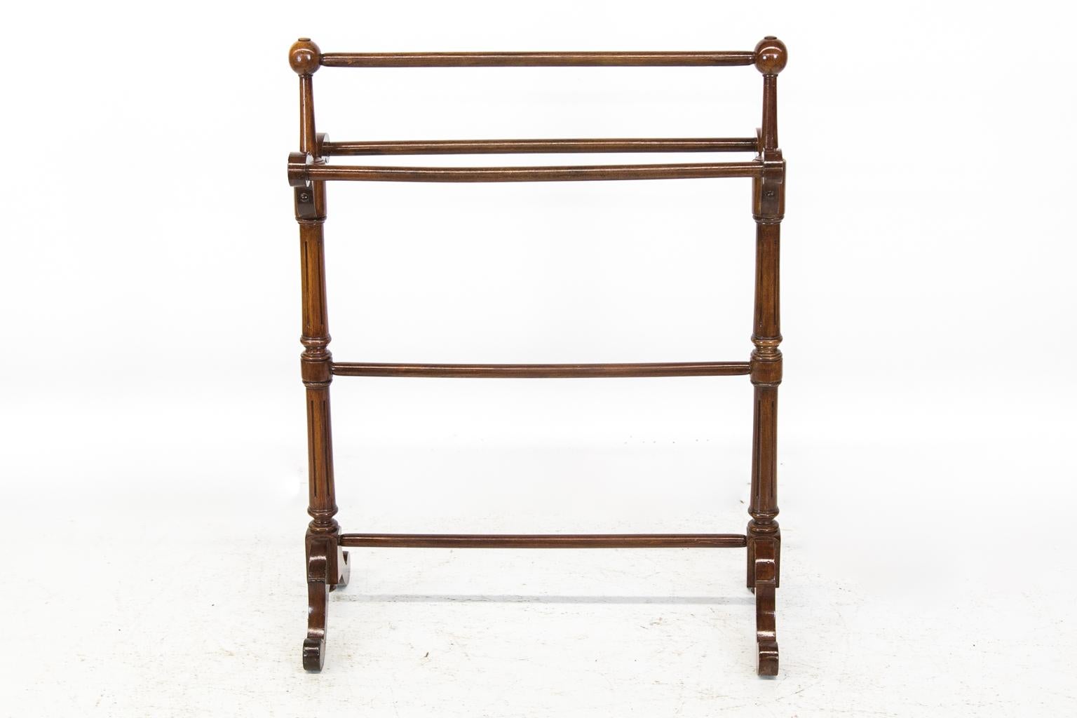 English walnut blanket/towel rack has reeded rail supports and scrolled arms with shaped feet.
  