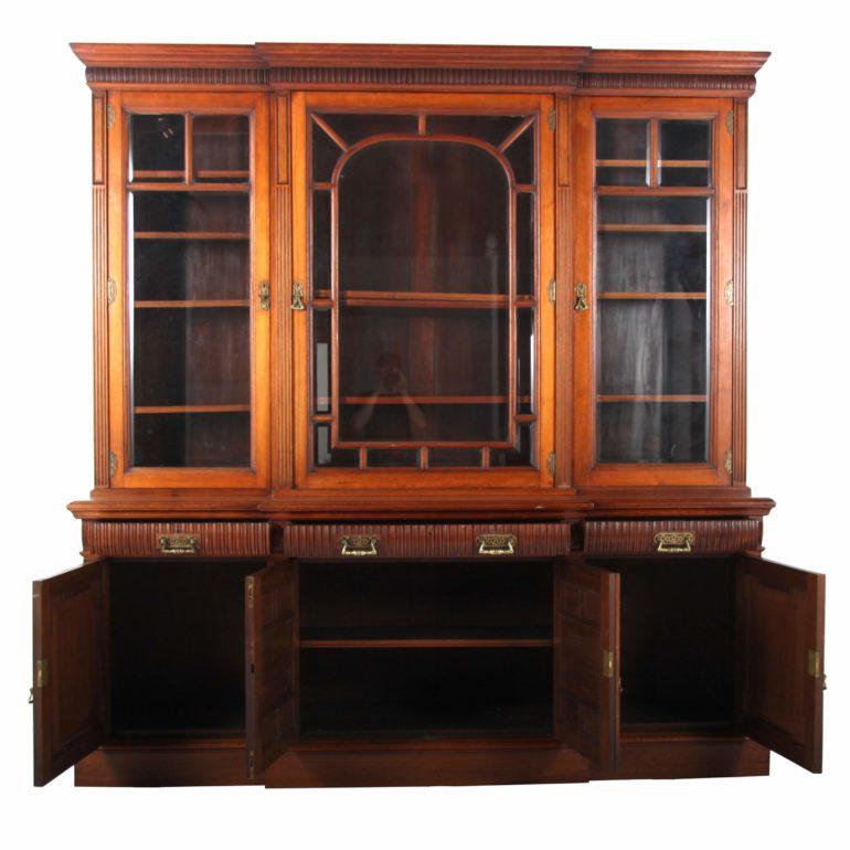A lovely example of late 19th century English cabinetry: A full 8 feet tall, a solid carved walnut and beveled glass breakfront bookcase by the distinguished London maker, W. Walker & Sons. Subtle brass fittings nicely offset the warmth of the