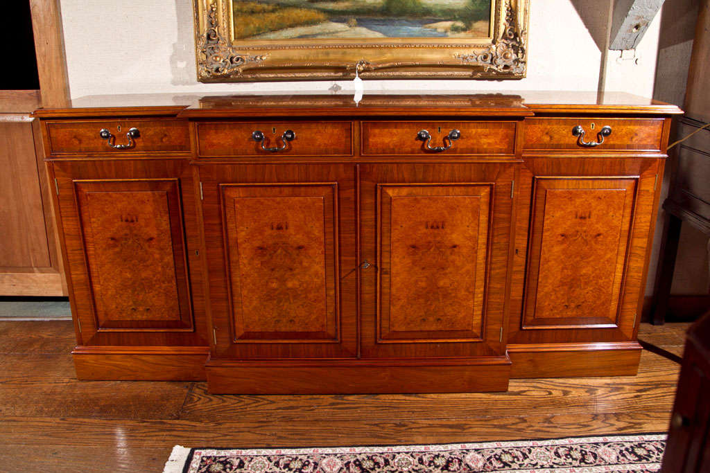 This walnut and walnut burl breakfront server/credenza offers clean design and copious storage space while bridging the divide between modern and traditional. The Classic style and tightly burled walnut grain combine to give this server a look that