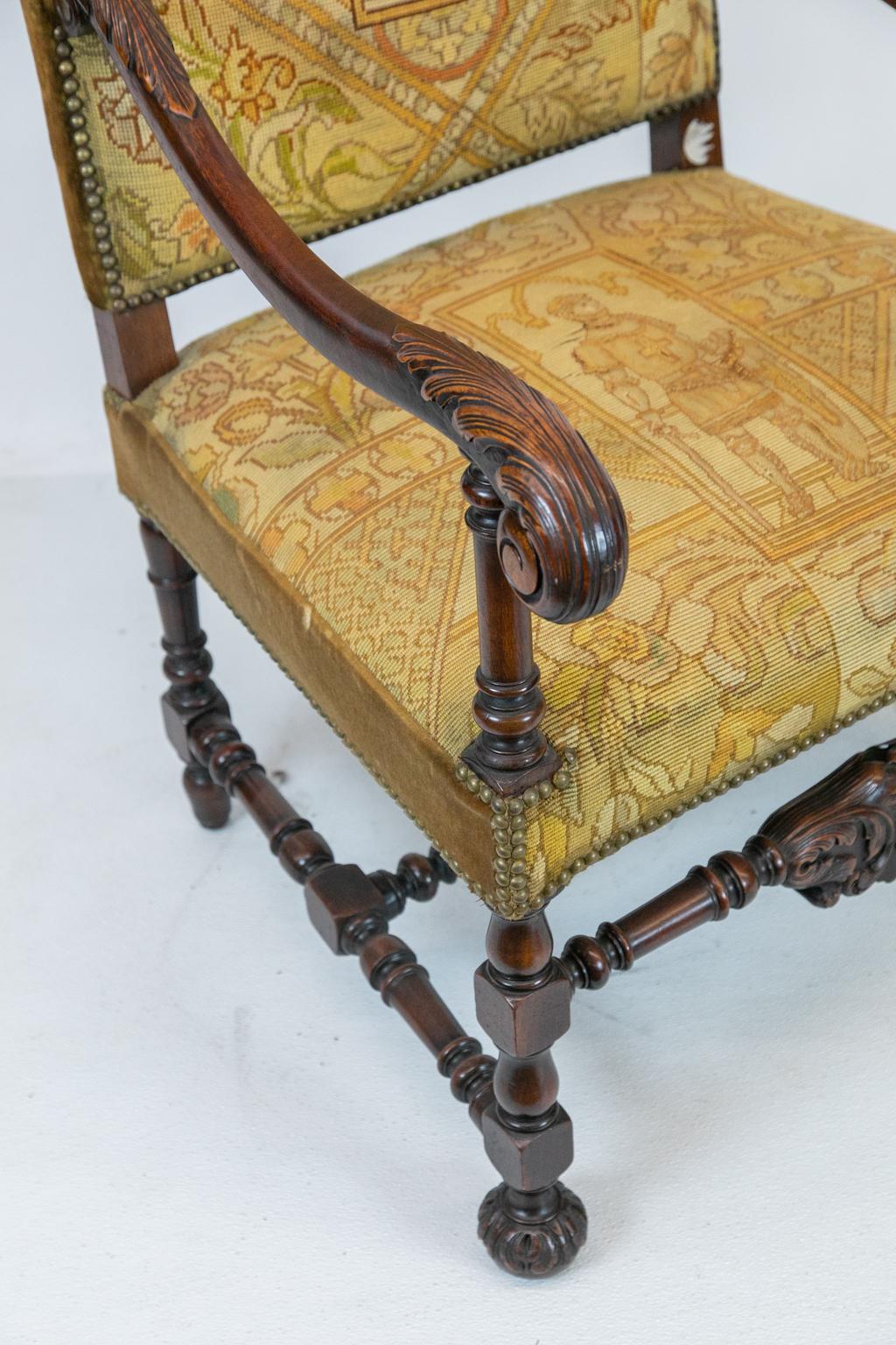 English walnut carved needlework armchair, the back and seat stitched with birds, dogs, and deer. The center panels are stitched with holy warriors done in petit point. The arms are carved with acanthus leaves and the base has a double cross