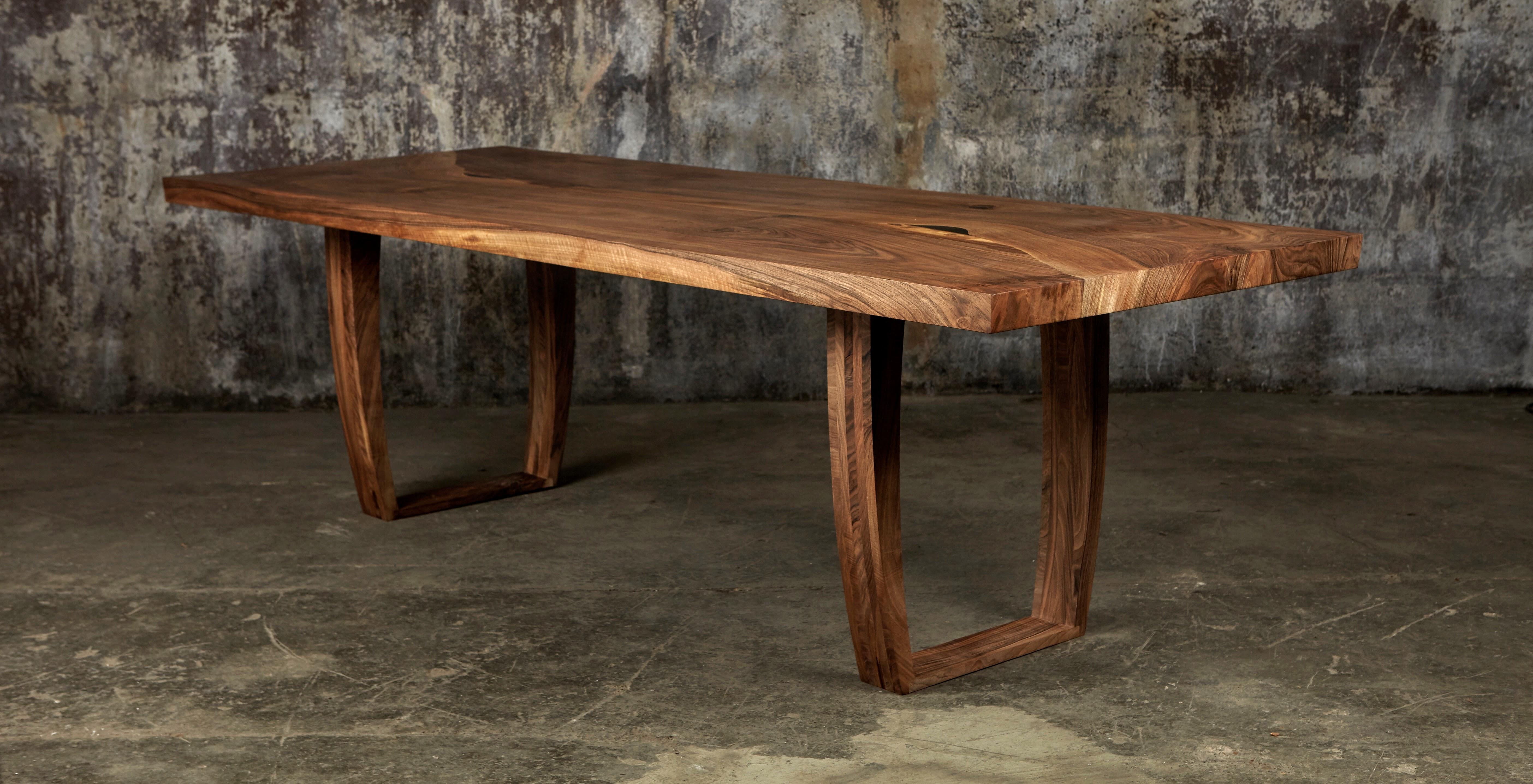 Commissioned for a private client, this dining table was the first of three tables we made from a single trunk of English walnut that was rich in ripple. 
The ripple in this walnut, when sanded and given a coat of oil, gives the illusion of being a
