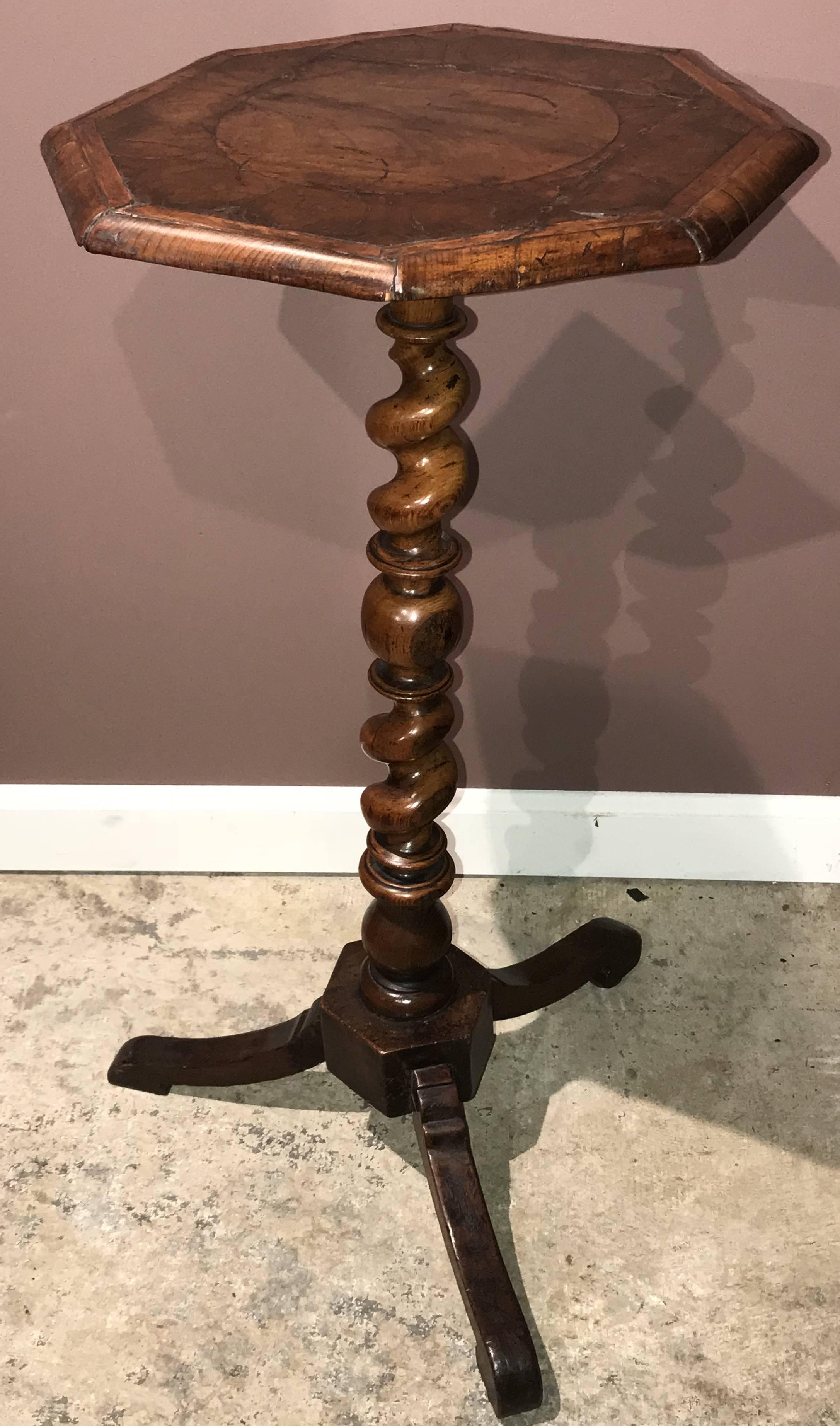 A fine example of an English walnut candle stand or side table with octagonal top with circular and banded marquetry, probably inlaid with crocus and olive wood, surmounting a rope twist carved stem, all supported by a square tripod base with